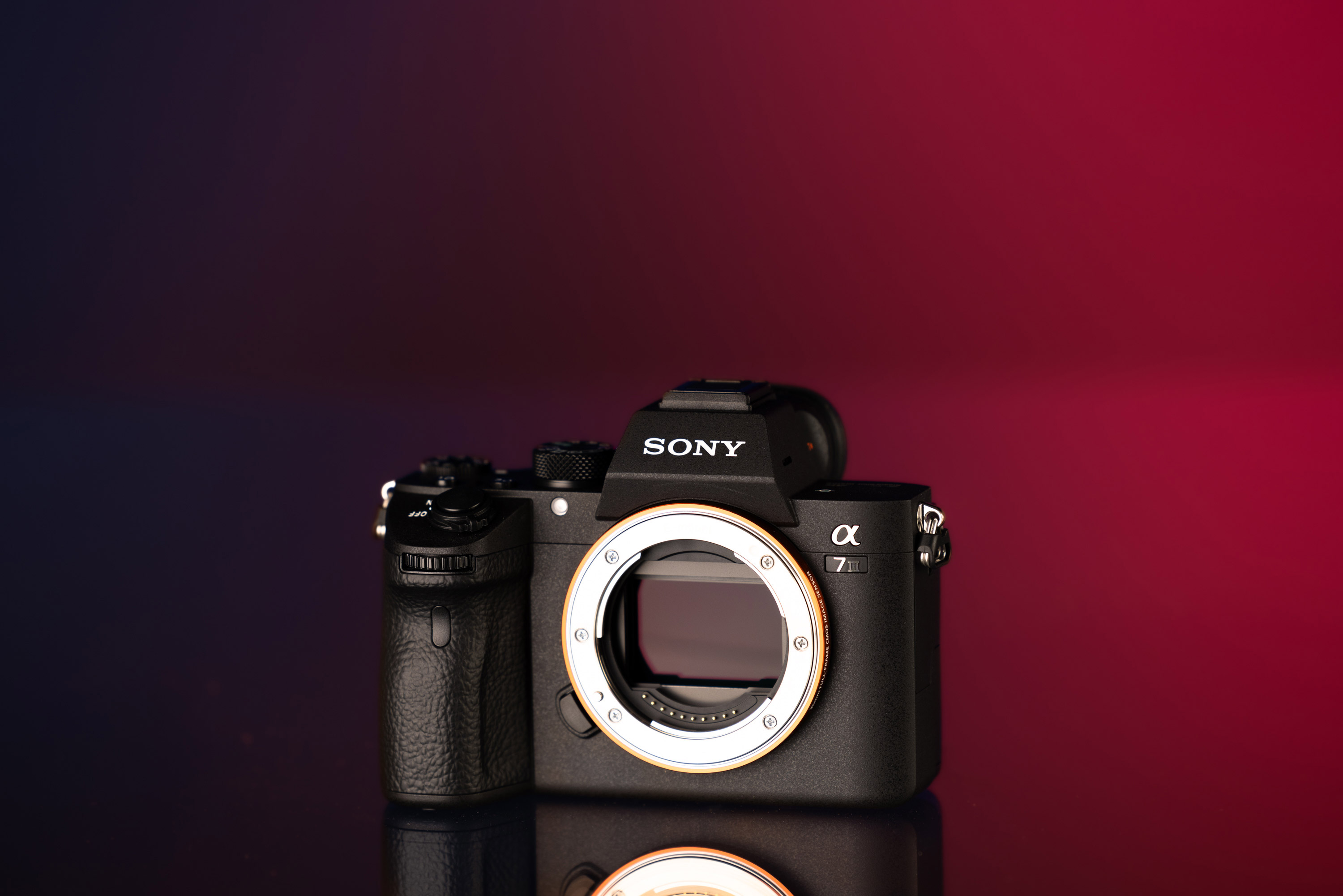 Gebrauchte Sony A7 III vor einem blau-roten Hintergrund.