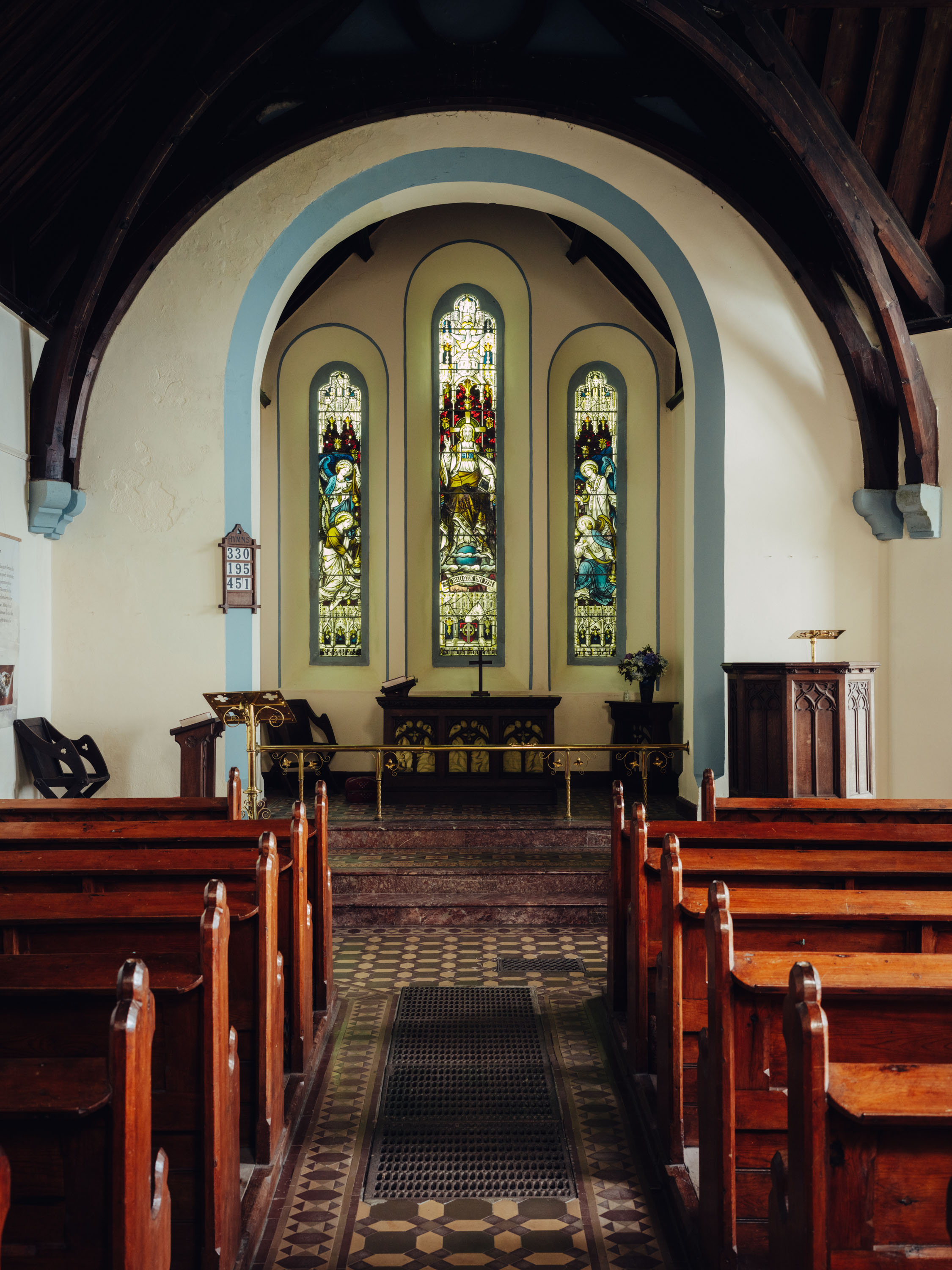 Das Innere einer Kirche mit einer Holzdecke und Kirchenbänken, mit Buntglasfenstern vorne, fotografiert von Ian Howorth mit einer Hasselblad X2D 100C