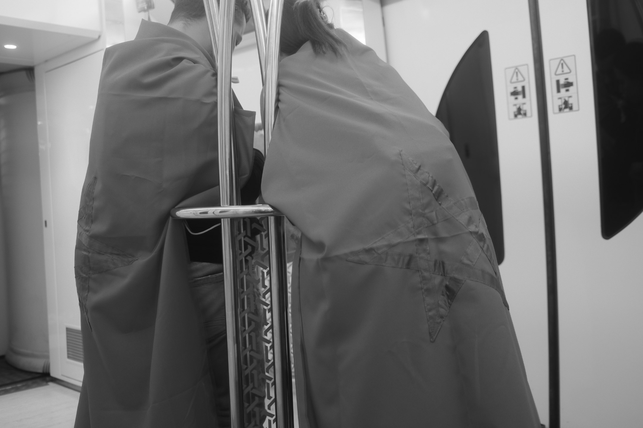 Photo en noir et blanc de deux supporters marocains, enveloppés dans des drapeaux, dans les transports commun pendant la Coupe du monde 2022, prise par Ryu Voelkel avec un Fujifilm X100V