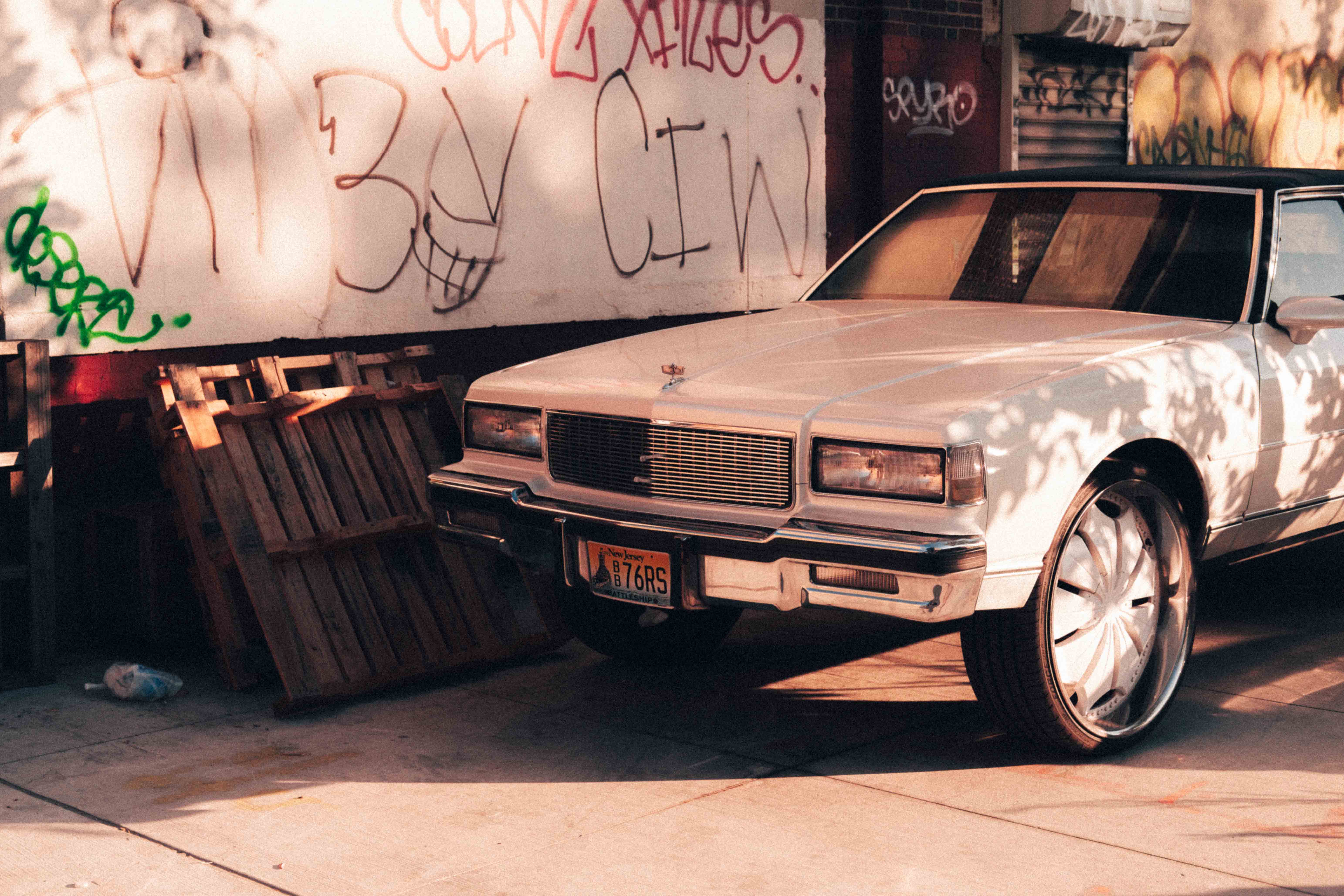 A classic vintage car parked by a graffitied wall bathed in lovely soft sunset light. Shot on the X-Pro 3 by Ian Howorth.