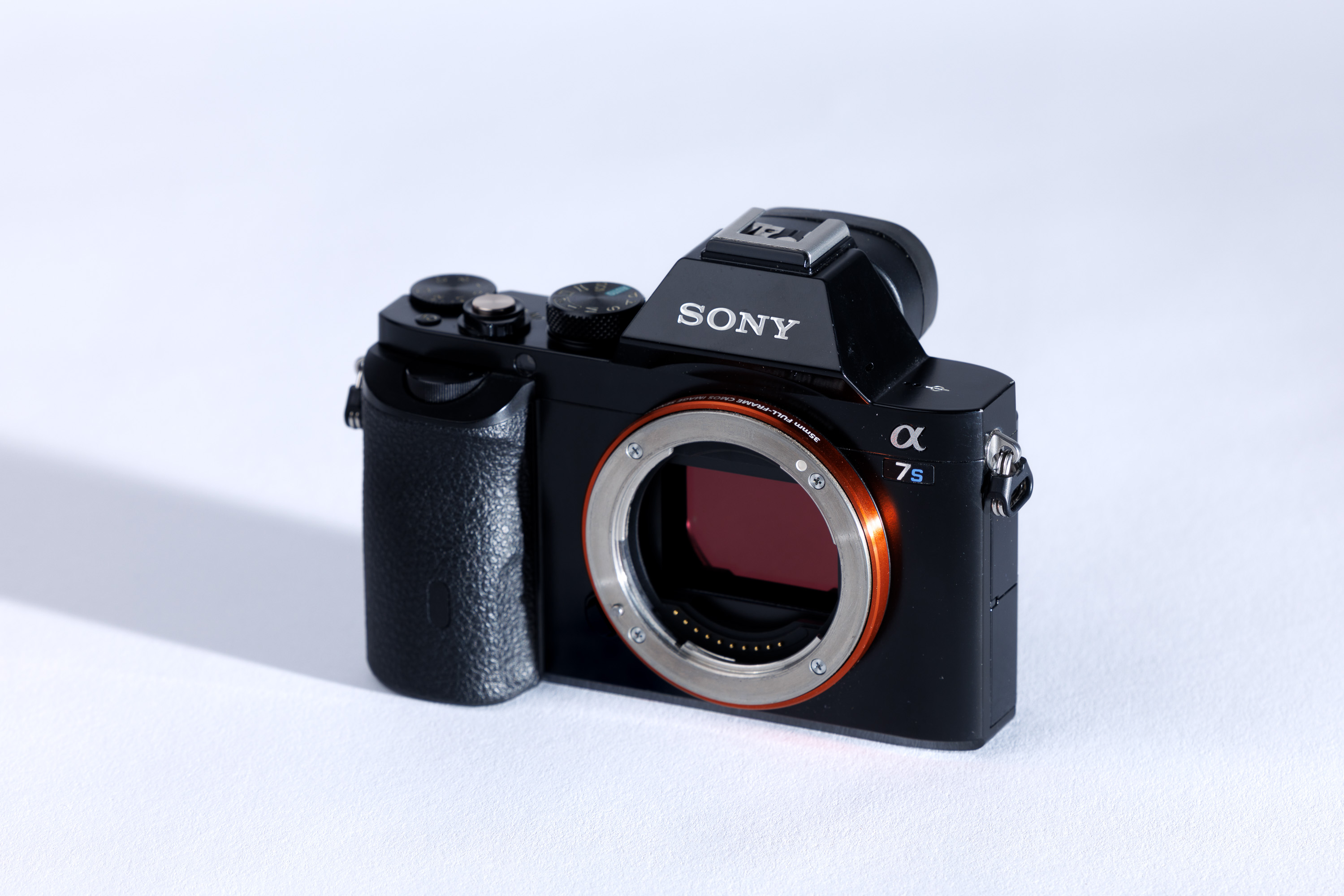 A used Sony A7S body on a white background, with a shadow to the left.