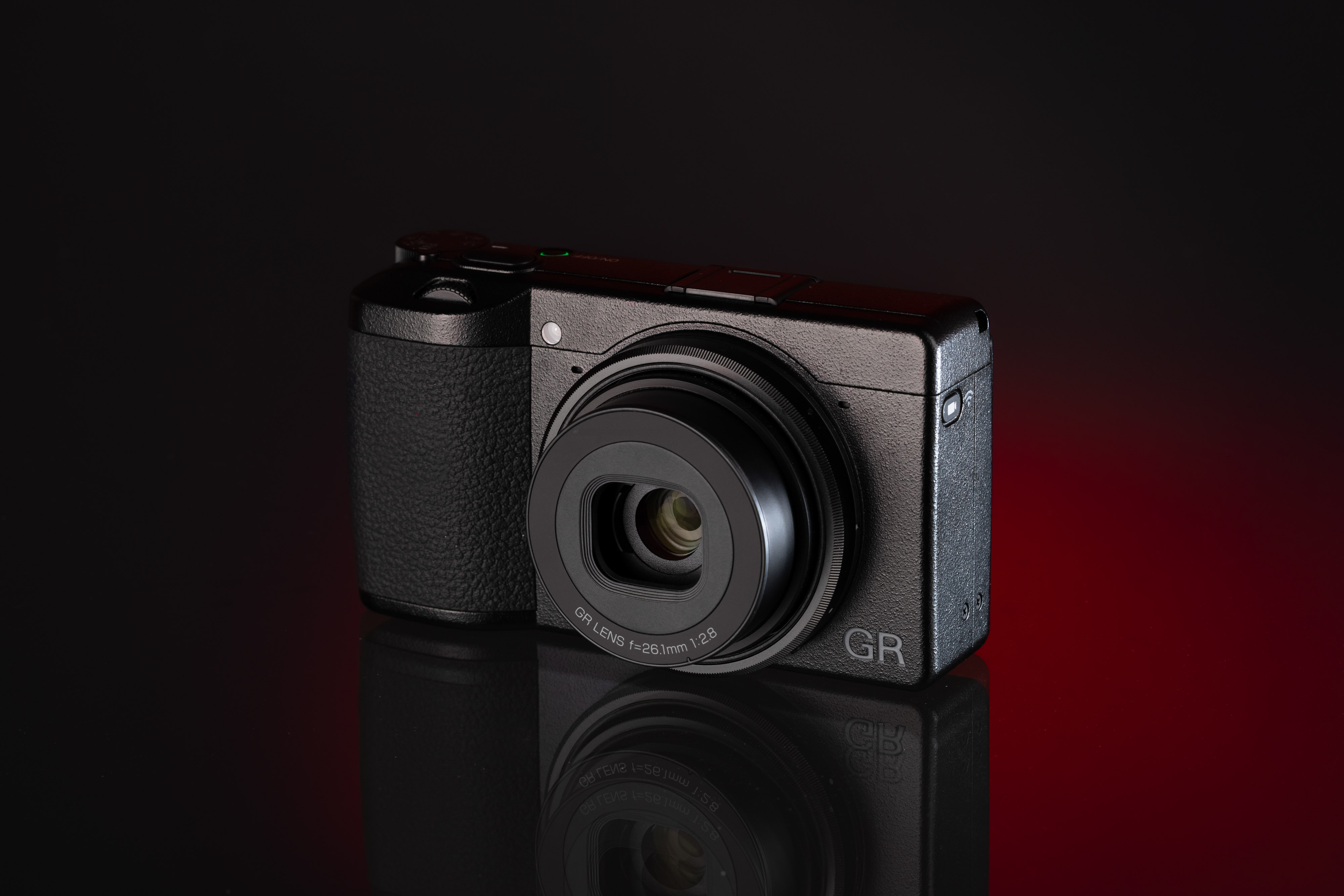 Ricoh GR IIIx vor einem rot-schwarzen Hintergrund