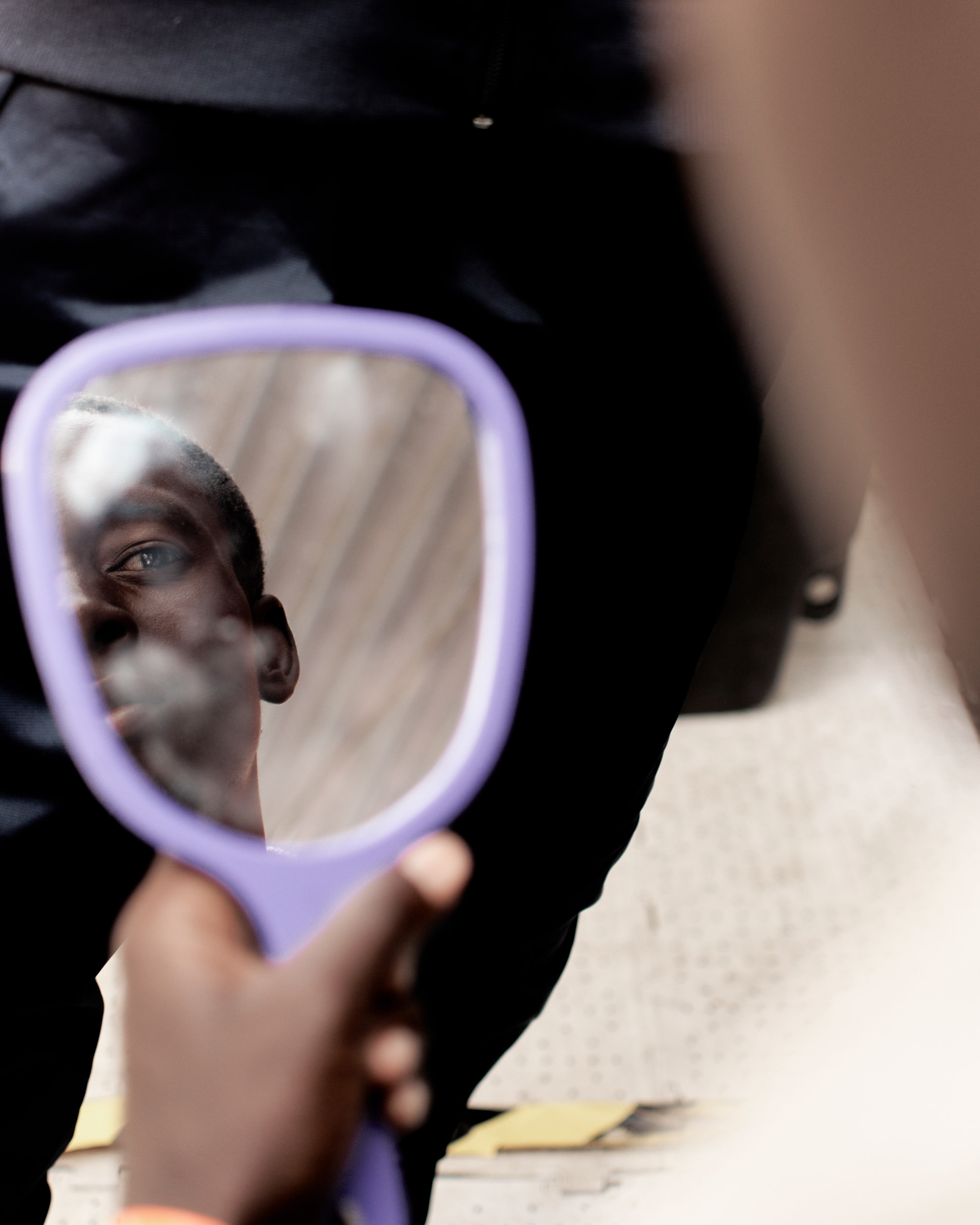 Reflection of a person in a purple hand mirror.