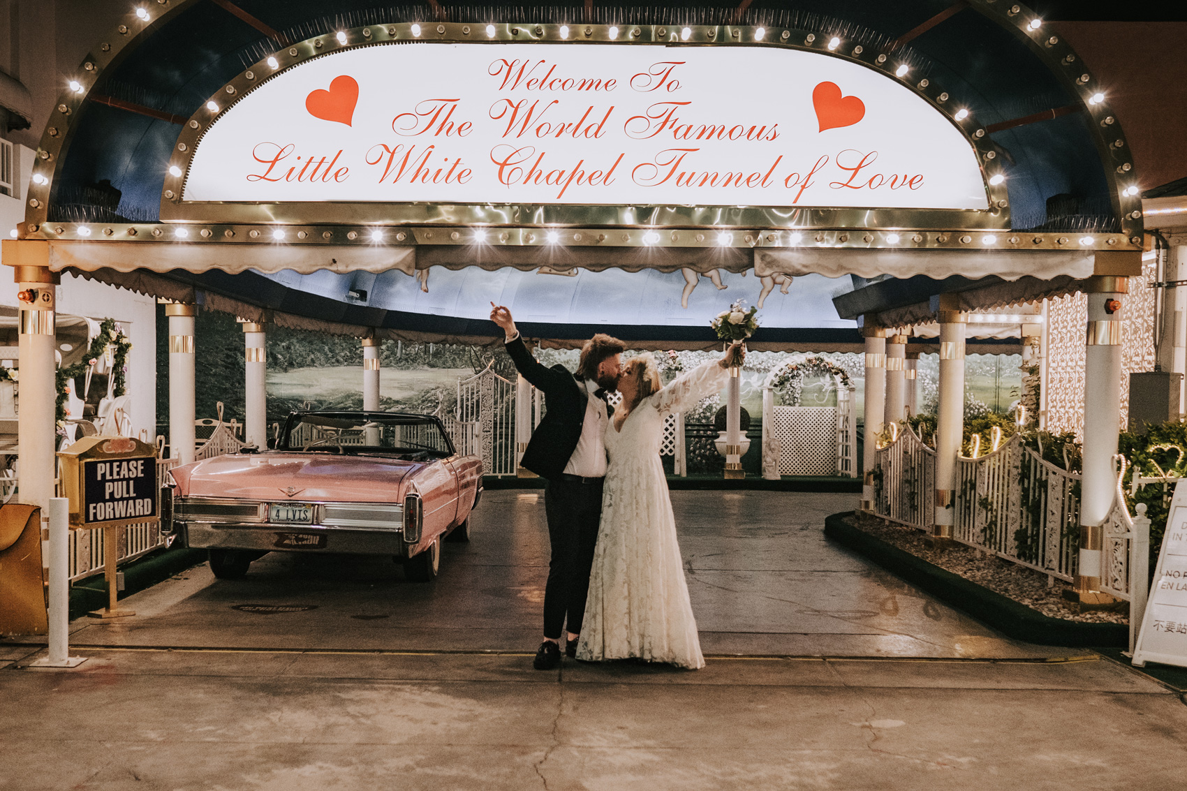 Couple posing in front of the World Famous Little White Chapel Tunnel of Love