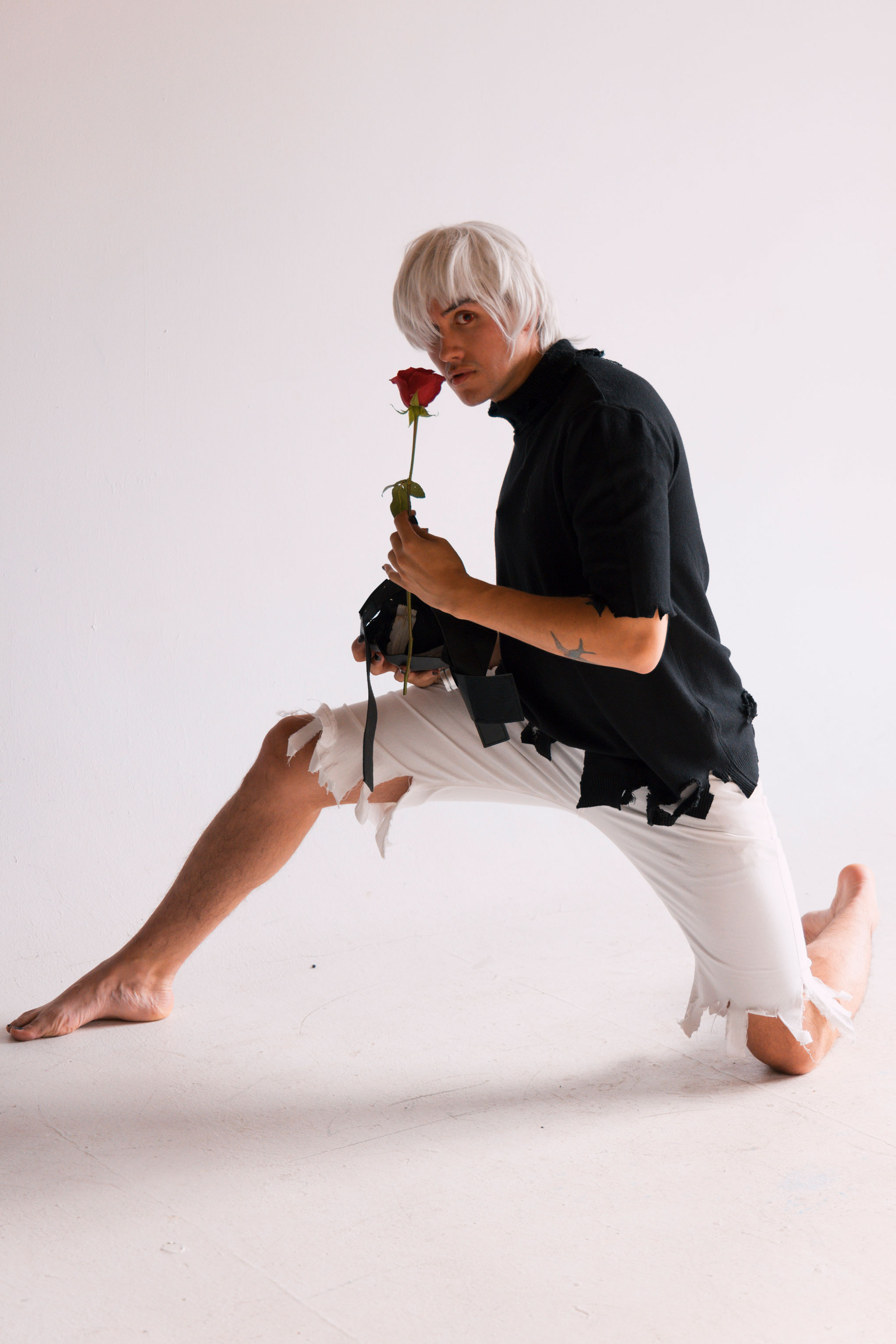 Anime cosplayer poses with a red rose.