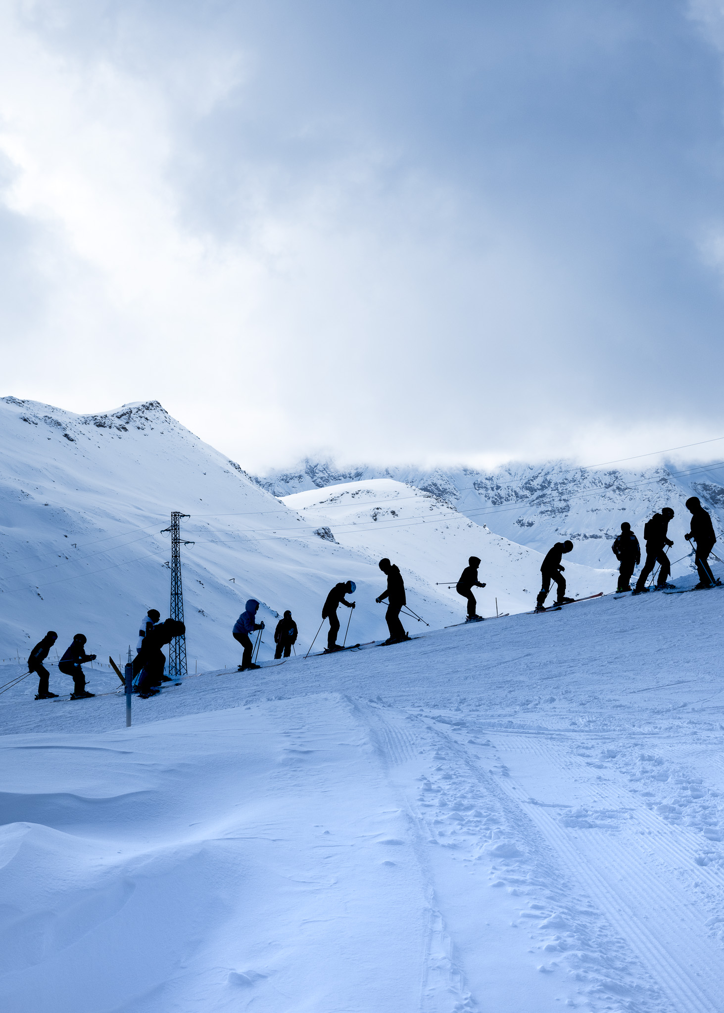 Skiers going up and down a hill in the Alps. Taken on the Fujifilm X100VI by Amy Moore.