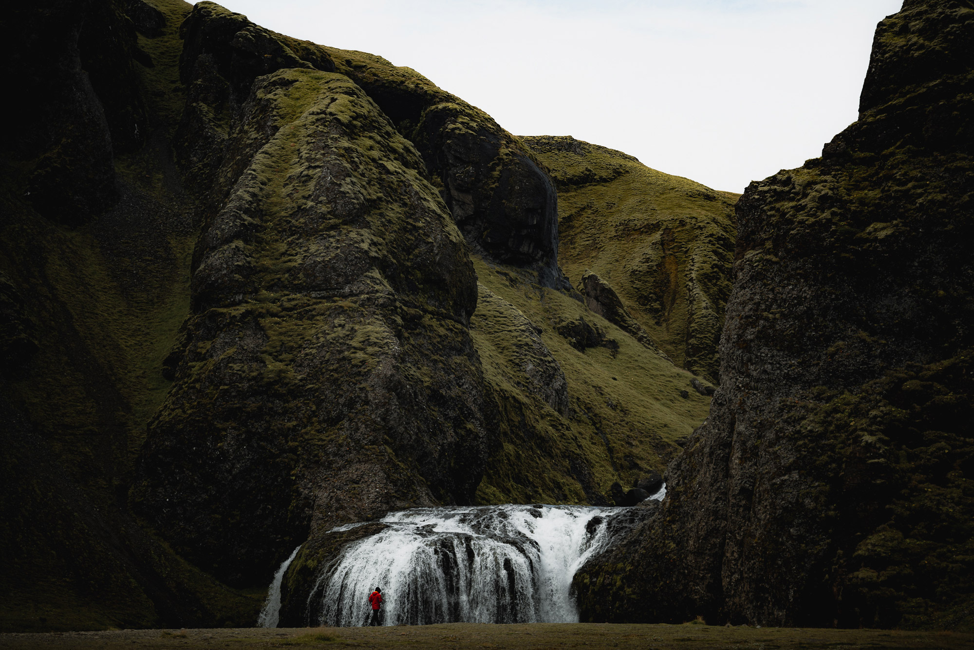 A small waterfall in Iceland appears at the bottom of a valley covered in grass, shot by Paul Watson with a Panasonic S1R