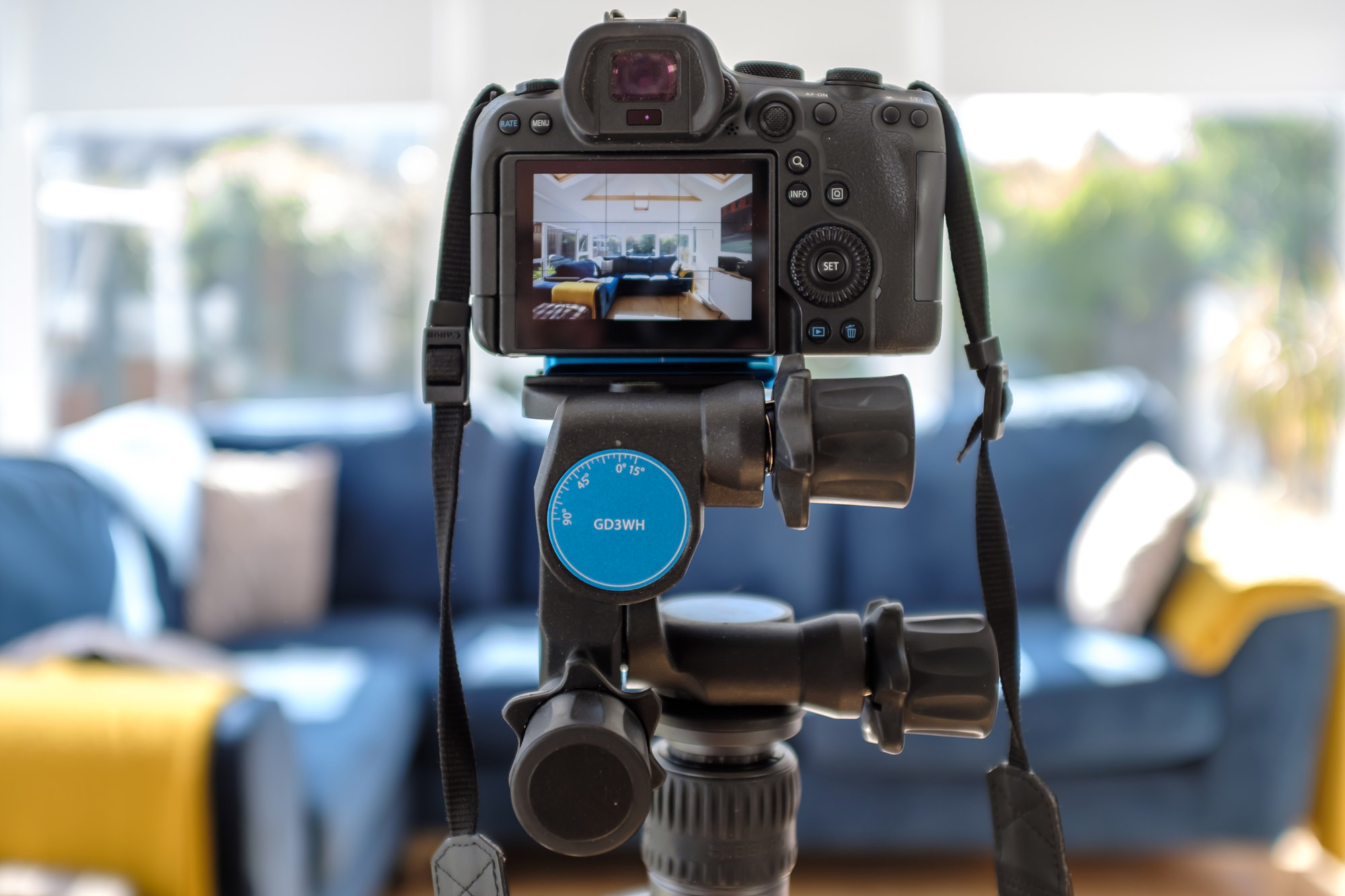 Een camera op een statief, met een blauwe bank en raam op de achtergrond, gefotografeerd door Paul Moore met de Fujifilm X100F