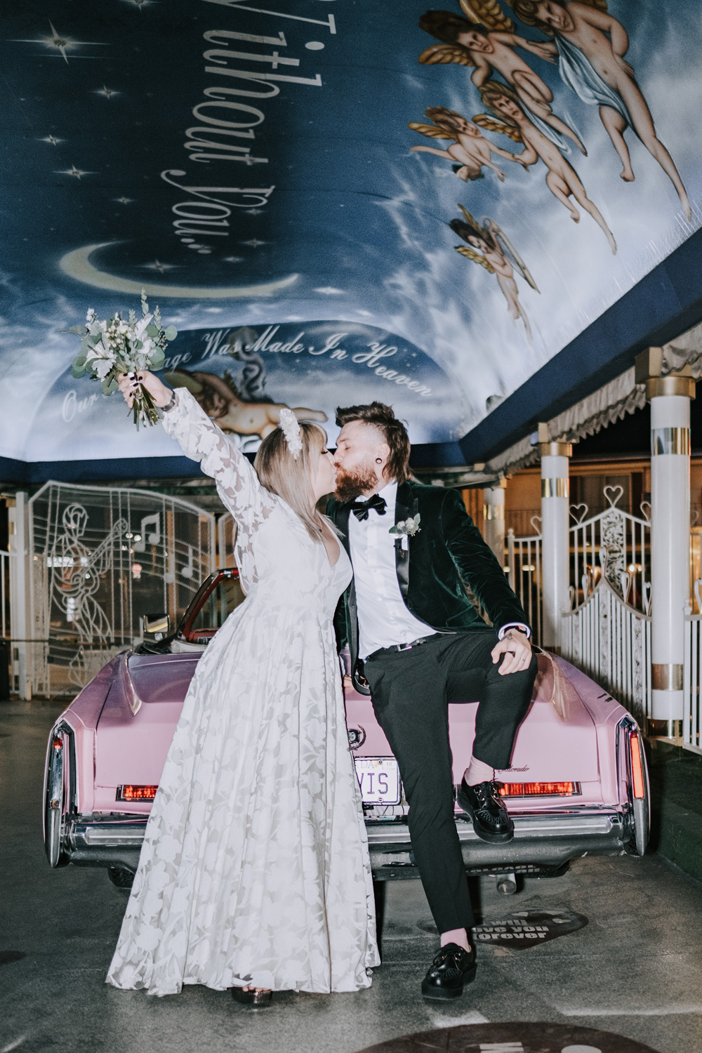 Des mariés s'embrassent assis à l'arrière d'une voiture rose dans le tunnel de l'amour de la Little White Chapel à Las Vegas, photographiés par Matthew Palmer avec un Fujifilm X-T4.