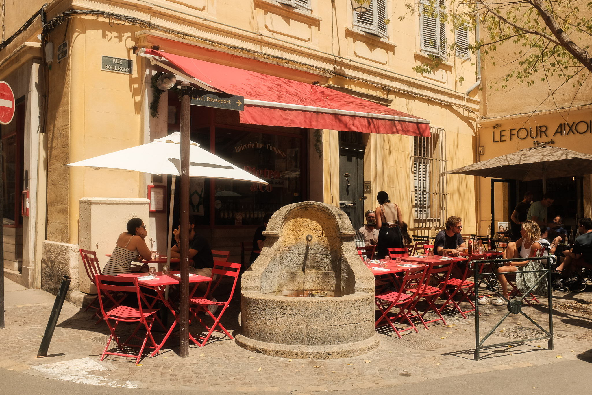 A cafe with red chairs and awning in Aix-en-provence. Taken on the Fujifilm X100T by Connor Redmond.