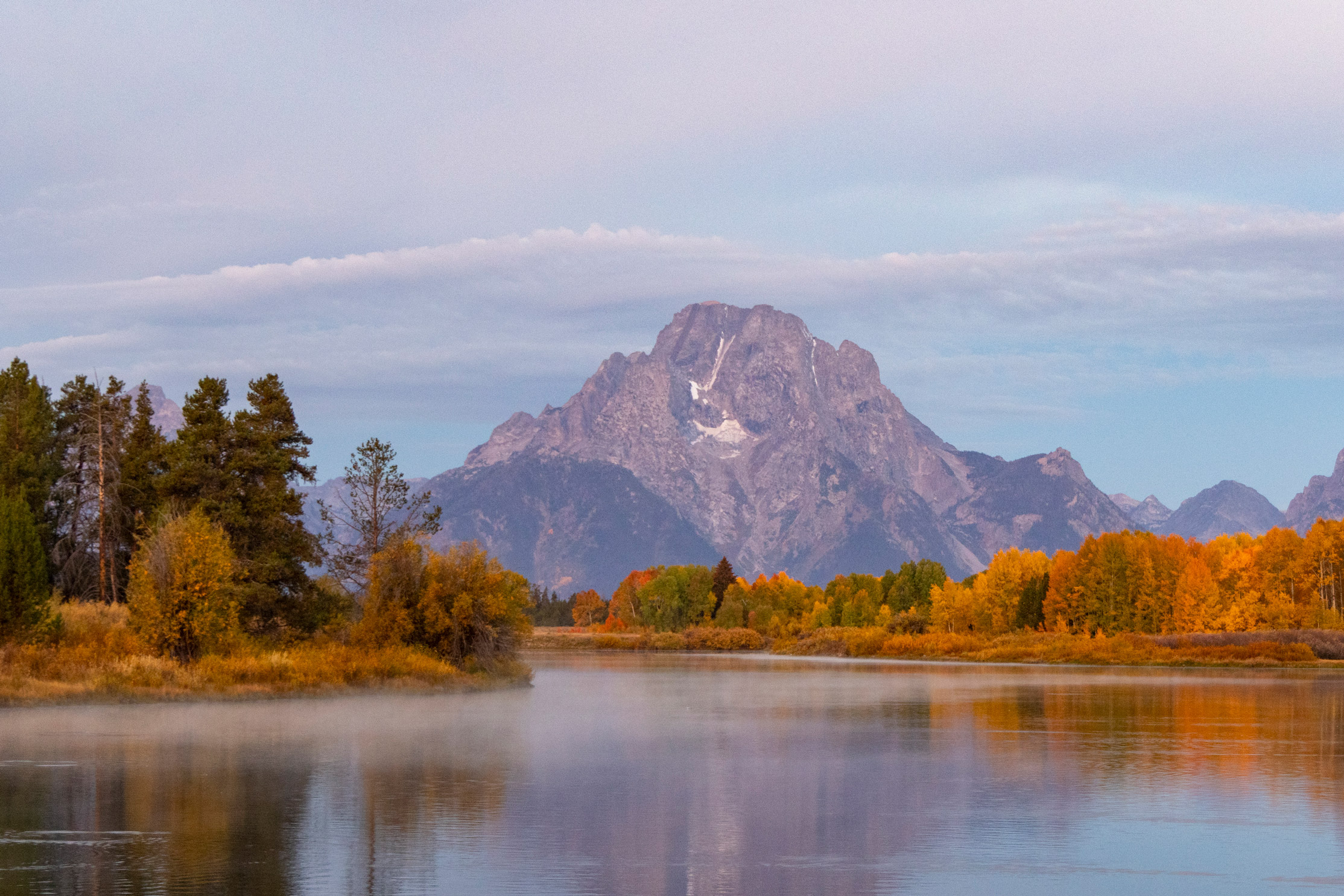 Herbstliche Aufnahme der Grand Tetons bei Sonnenaufgang am Oxbow Bend im Grand Teton National Park, Wyoming. Aufgenommen von Kristi Townsend mit einer Canon EOS R7.