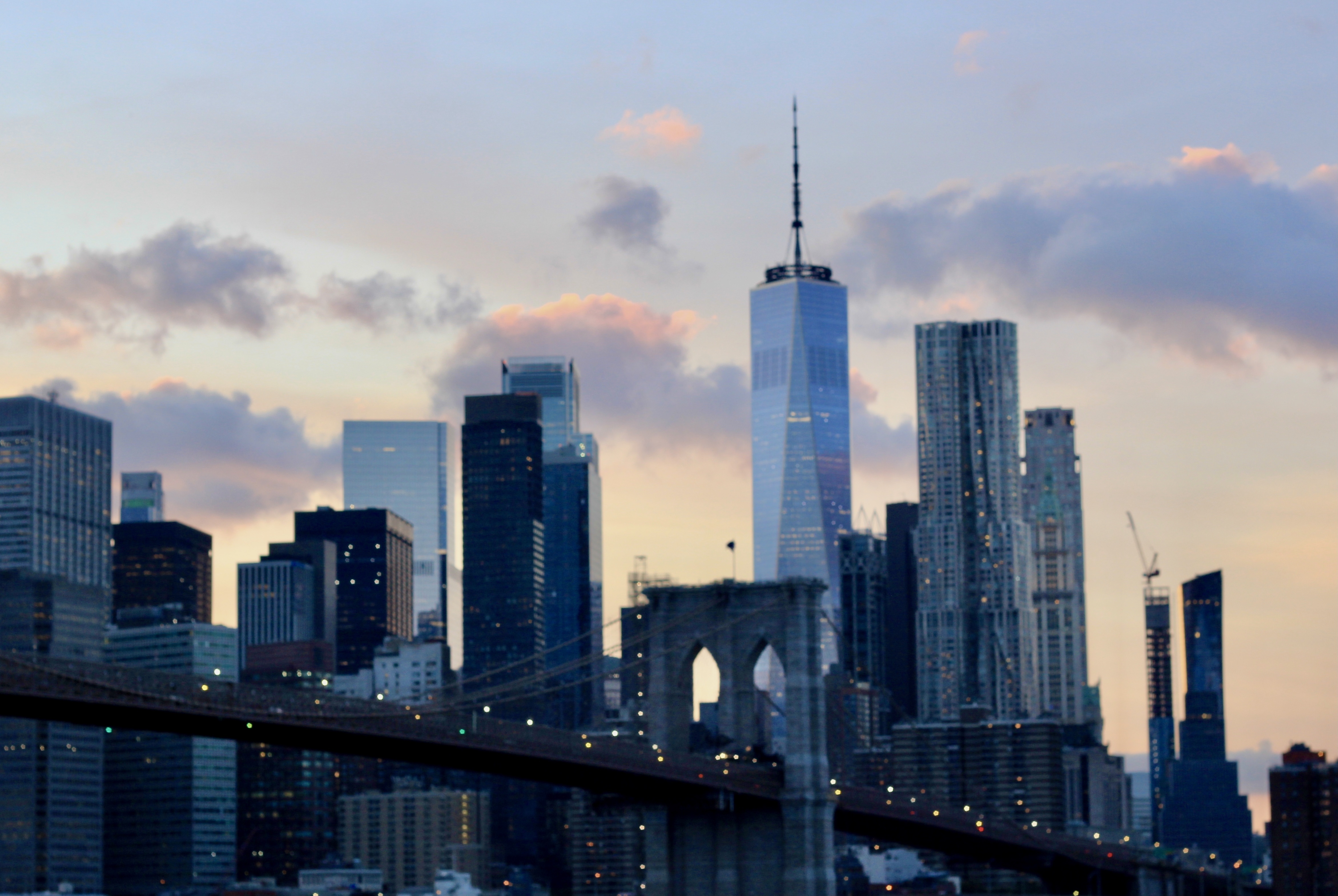 Photo du pont de Brooklyn et du One World Trade Center au crépuscule avec le ciel.