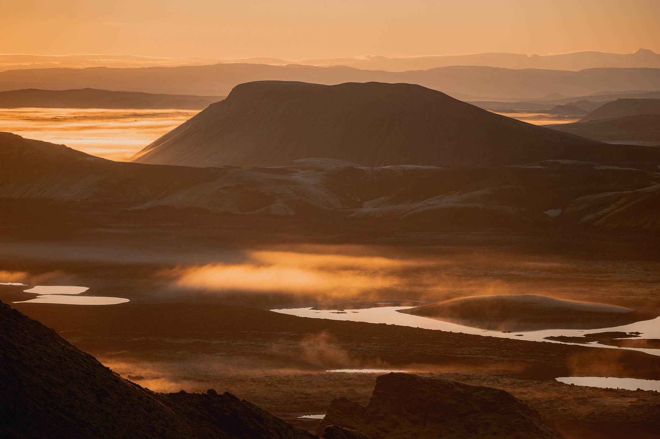 A mountain range surrounded by winding rivers and fog during an orange sunrise in Iceland, shot by Paul Watson with a Nikon Z6