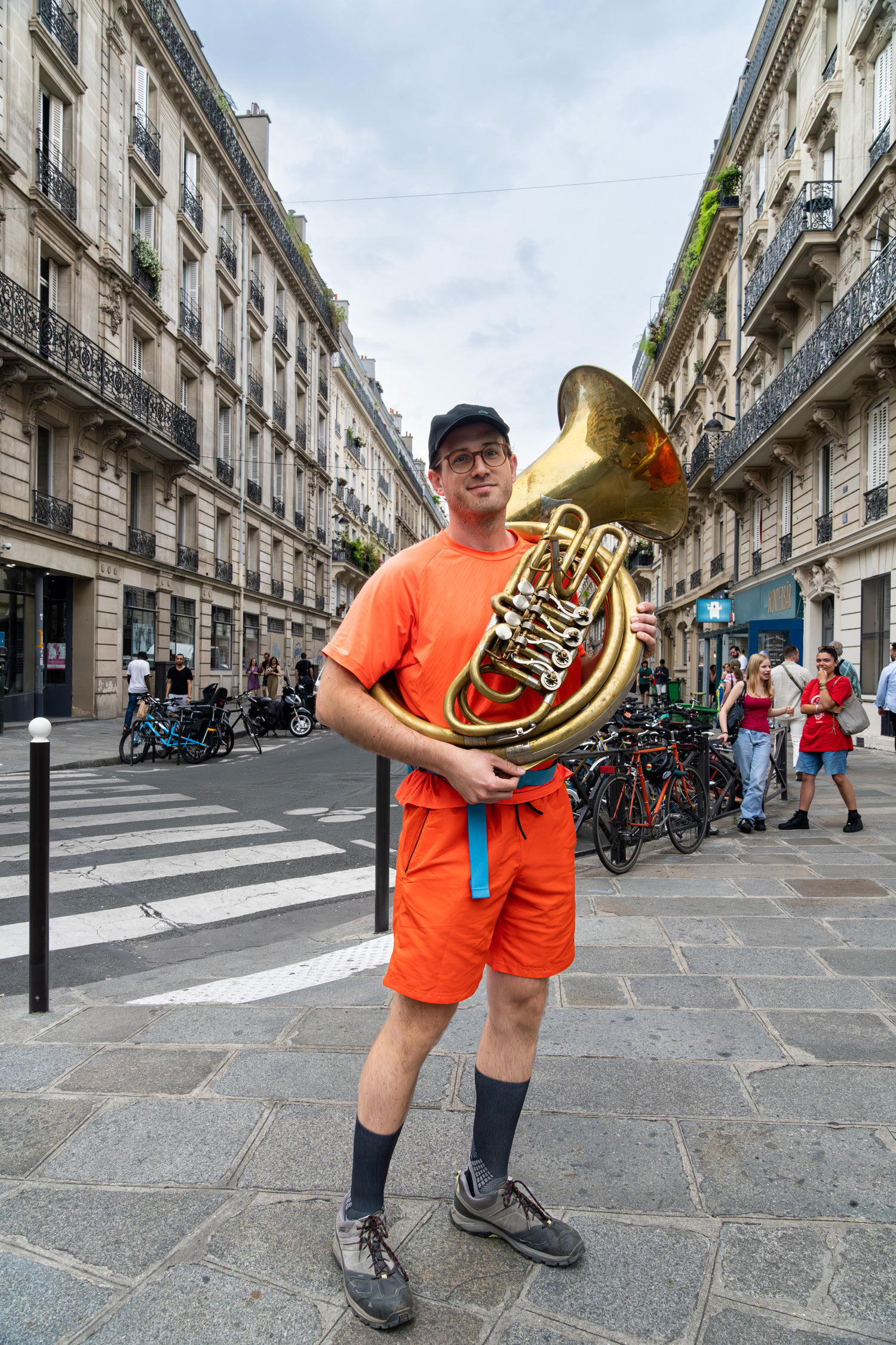 Musicien dans la rue, il est vêtu de vêtements de couleur orange. Photo prise par Marilu PArisi avec un Sony A7R V.
