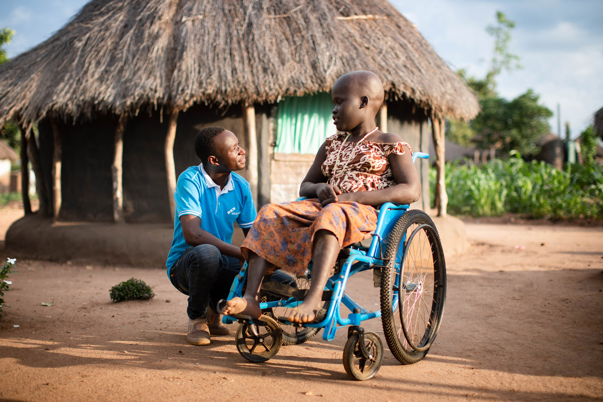 Un enfant en fauteuil roulant avec un membre du personnel de Hope Health Action à Bidi Bidi, en Ouganda, photo prise par Thomas Williams avec un Canon EOS 5D Mark IV.