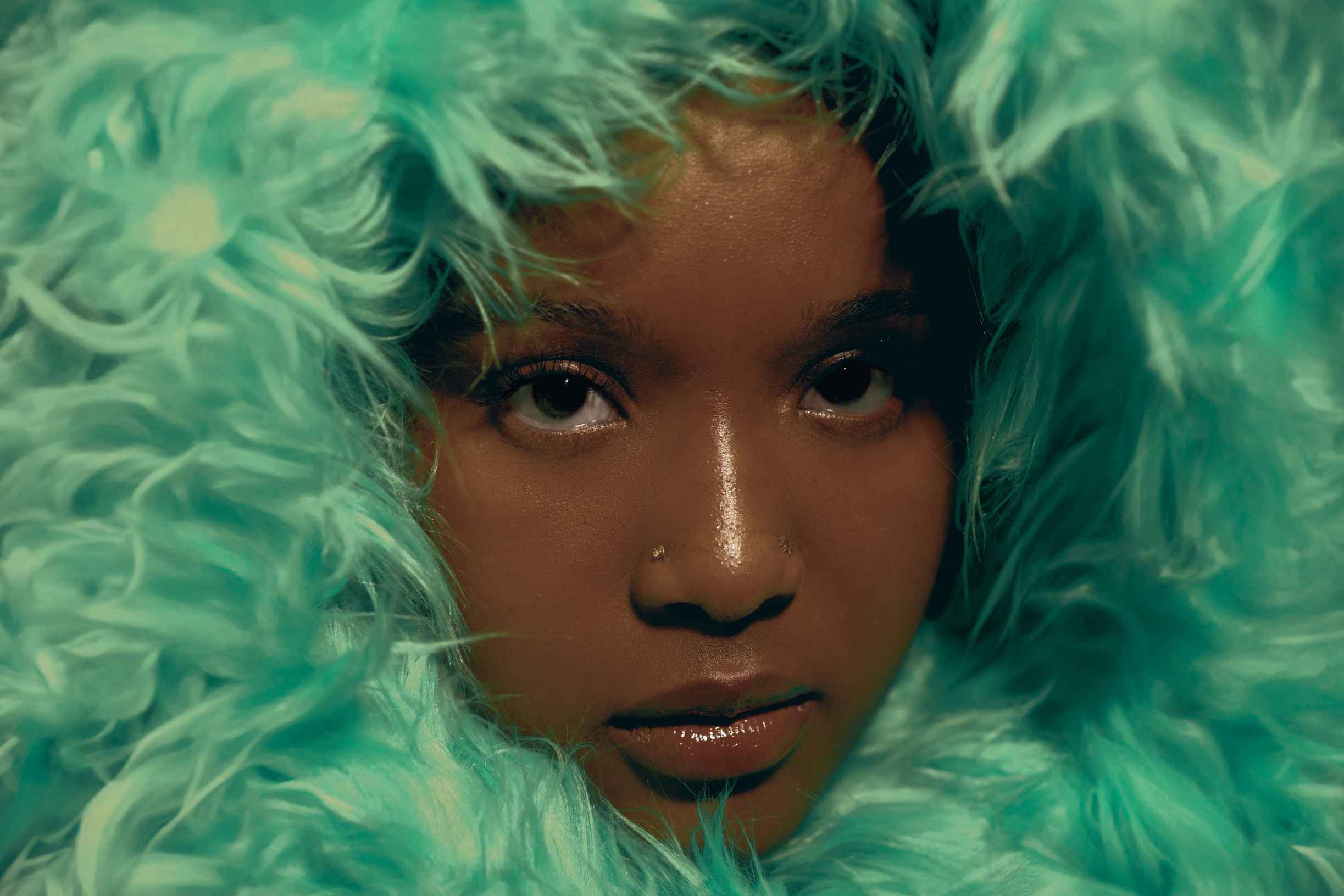 Person’s face surrounded by teal fuzzy material, by Kaylah Sambo on a Hasselblad X1D-50c.