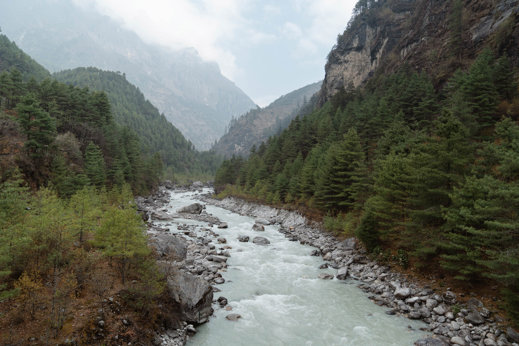 A river with mountains and trees on either side and on the horizon. Shot by Jack Anstey with the Sony A7 IV and Sony FE 24-70mm f/2.8 GM.