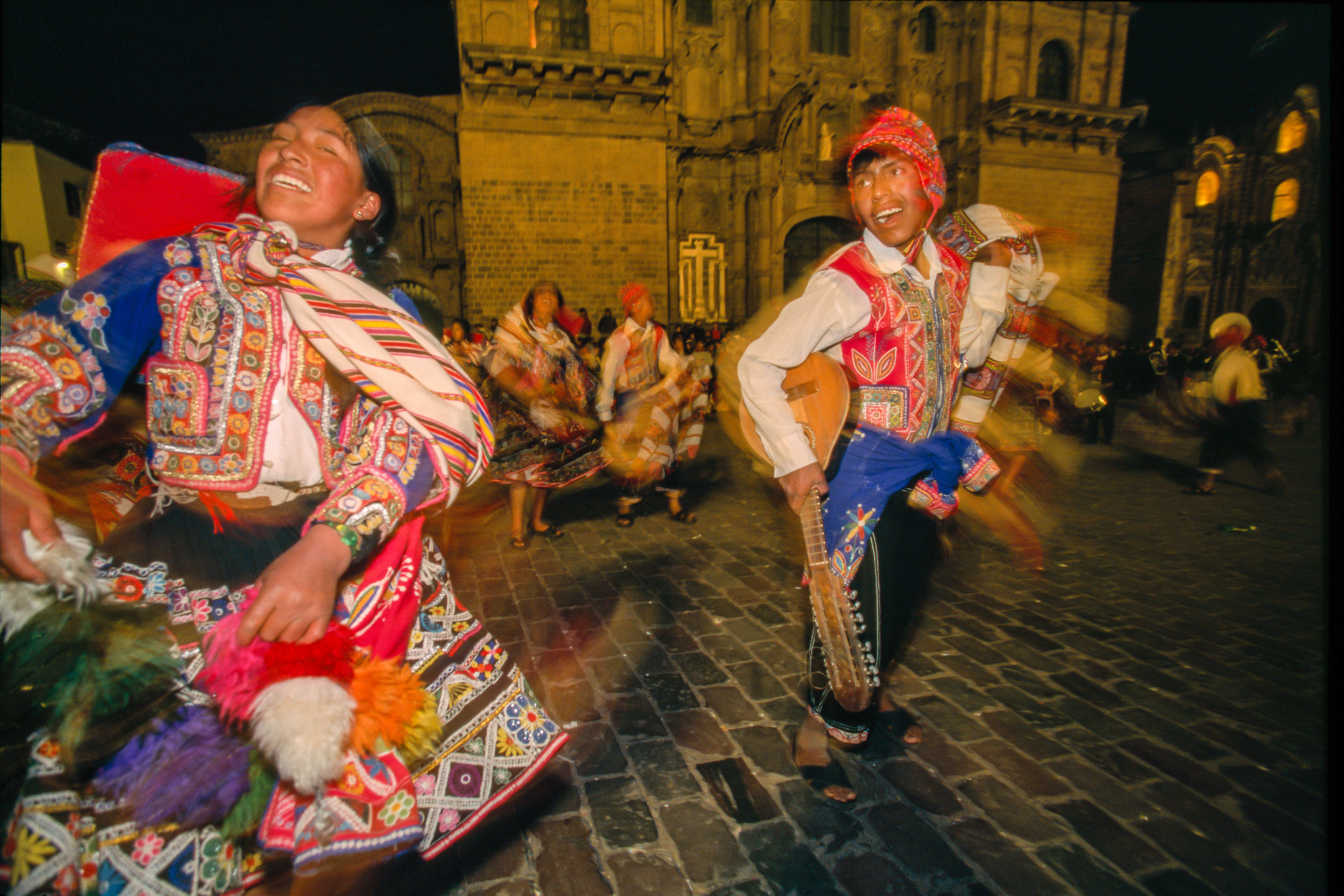 Tanzende Personen in farbenfroher Tracht beim Inti Raymi-Fest in Peru.
