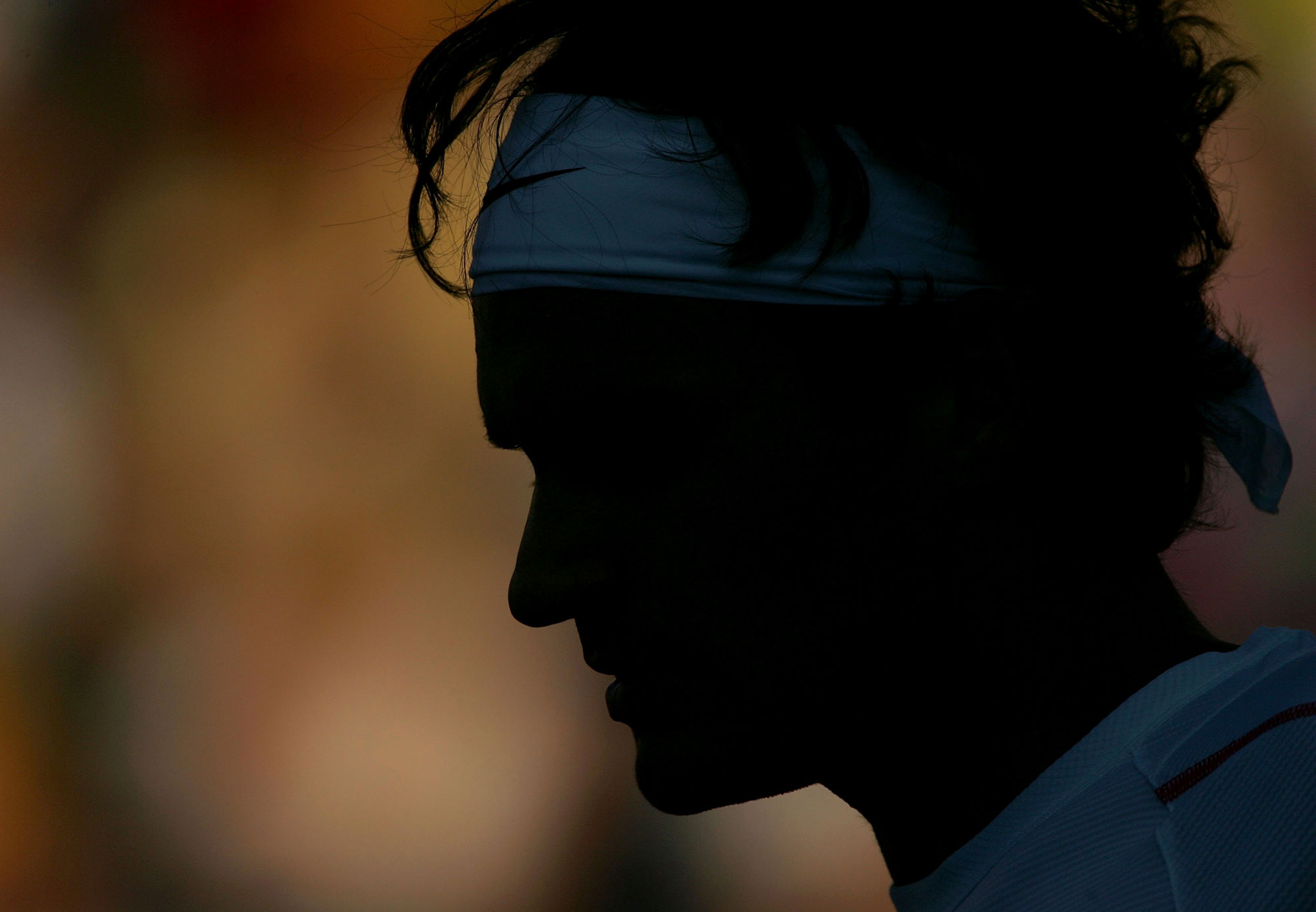 Roger Federer of Switzerland plays Xavier Malisse of Belgium during the Toronto Masters Series Rogers Cup in Toronto, Ontario, Canada. The background is blurred, and his face is just an outline, with his shirt and headband just about visible.