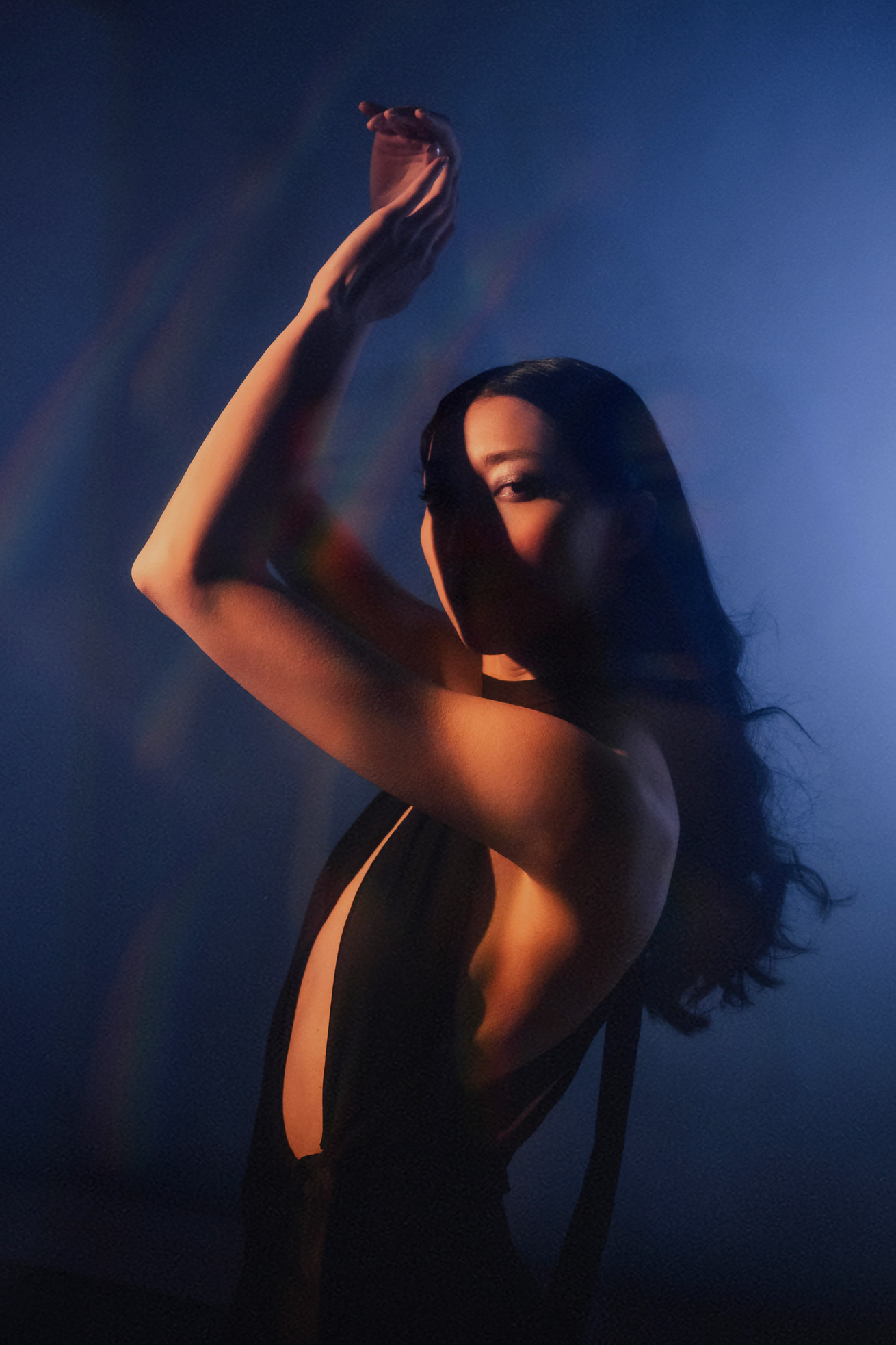 Model in front of blue background with hands in air, photo by Brandon Woelfel