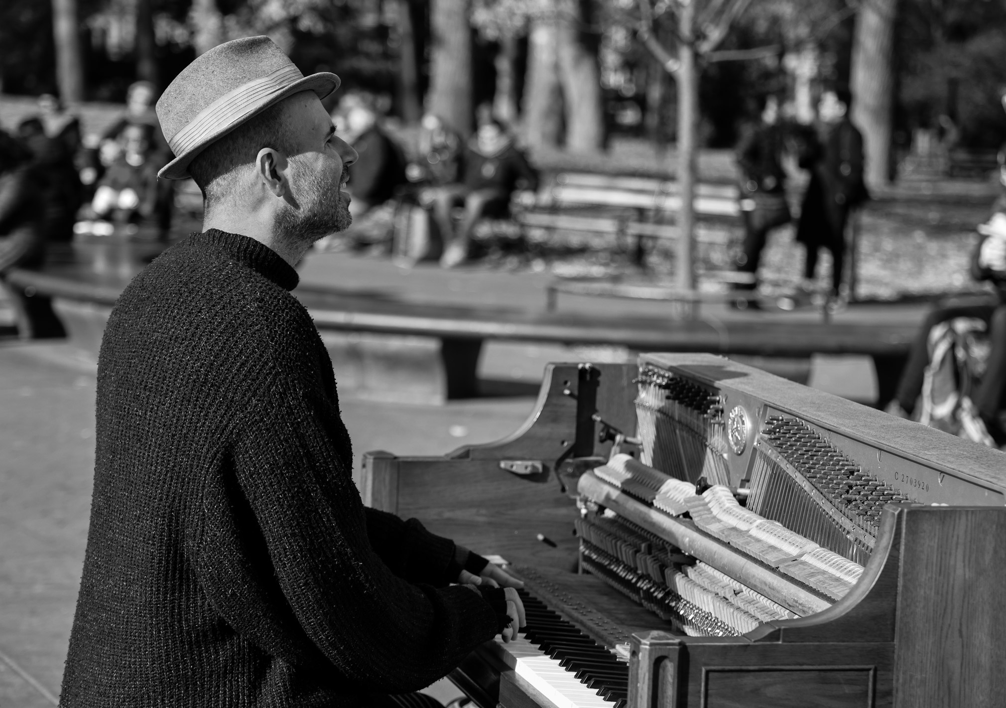 Black and white image of a man playing the piano in New York City’s Washington Square Park. Image shot on Canon EOS R5 by Berta Amelinaite.