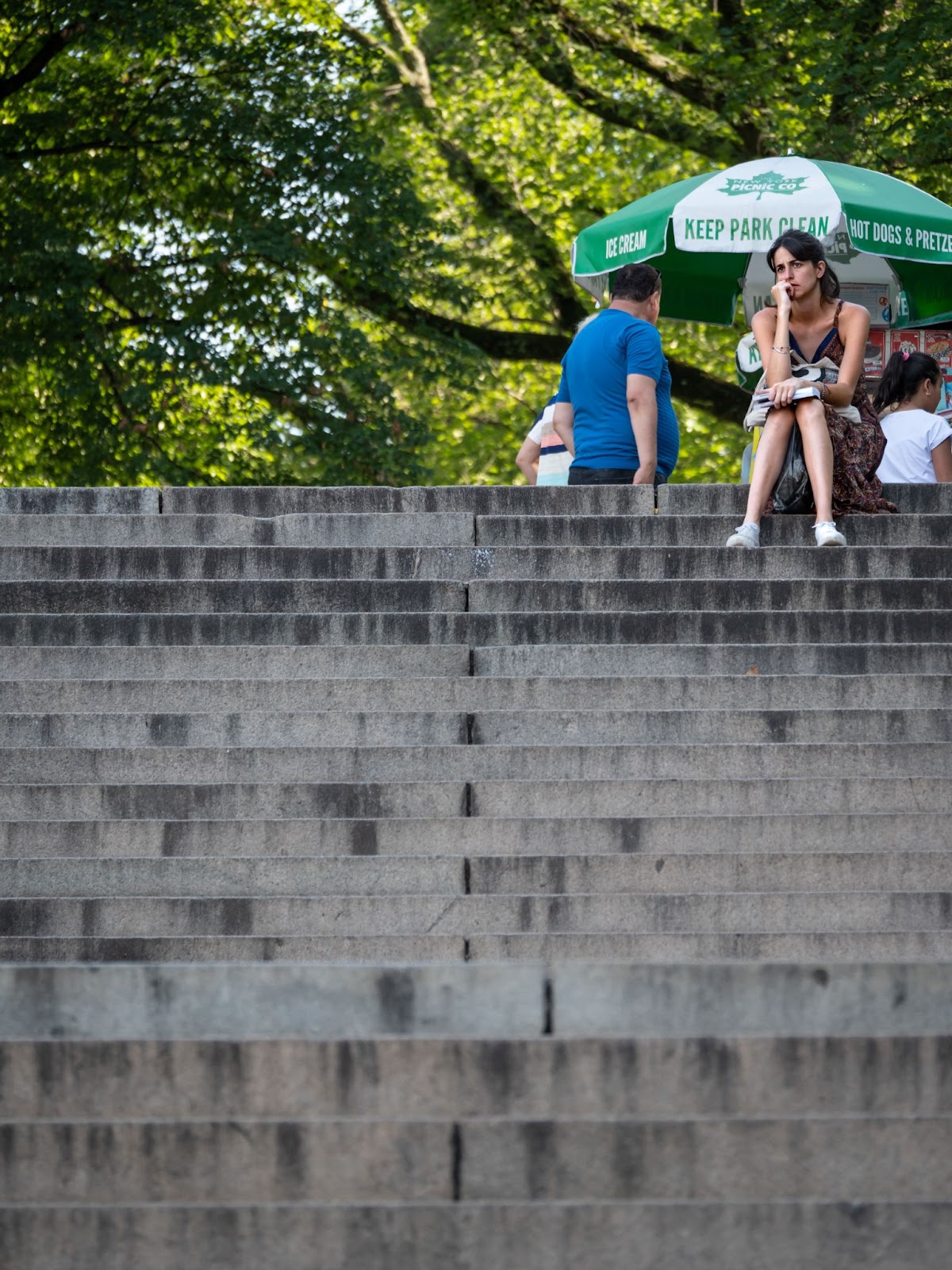 An image of a woman calmly seated on a set of concrete stairs in Central Park, New York. By Amy Moore.