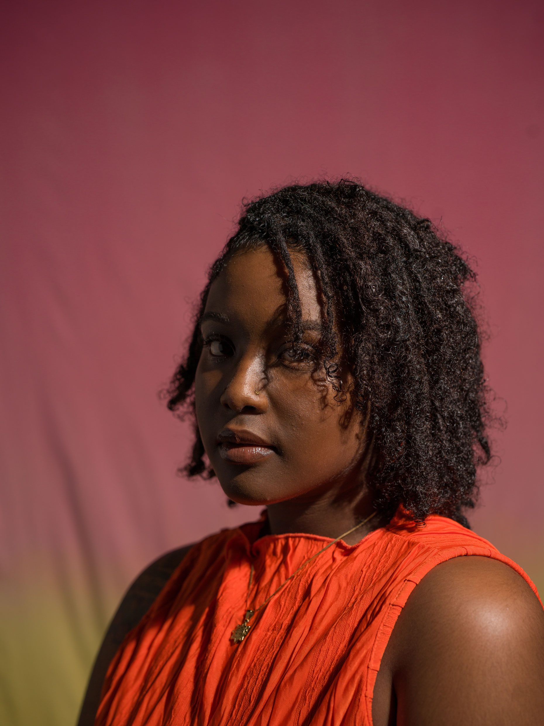 Portrait of a person with black curly hair using broad lighting technique. Taken by Kaylah Sambo on a Hasselblad X1D-50c.