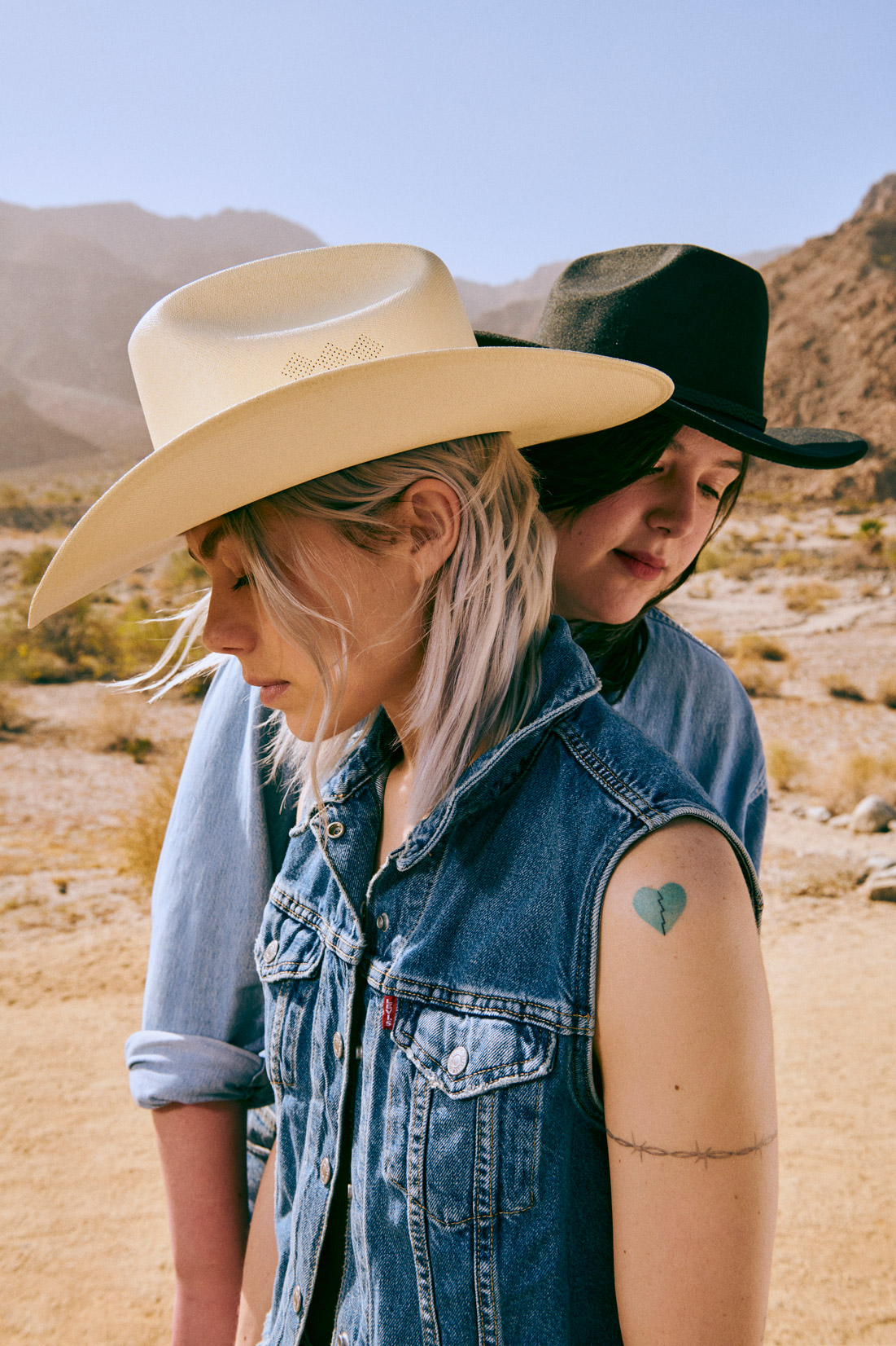 Phoebe Bridgers und Lucy Dacus von der Indie-Rock-Gruppe boygenius in der Wüste in Jeansjacken. Fotografiert von Lindsey Byrnes mit der Nikon D850.