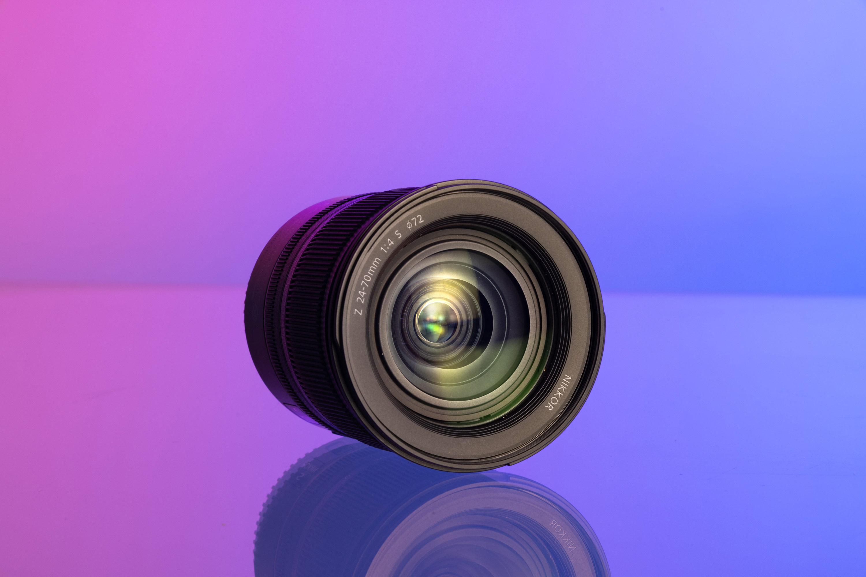 Nikon Z 24-70mm f/4 S lens on a purple and blue background.
