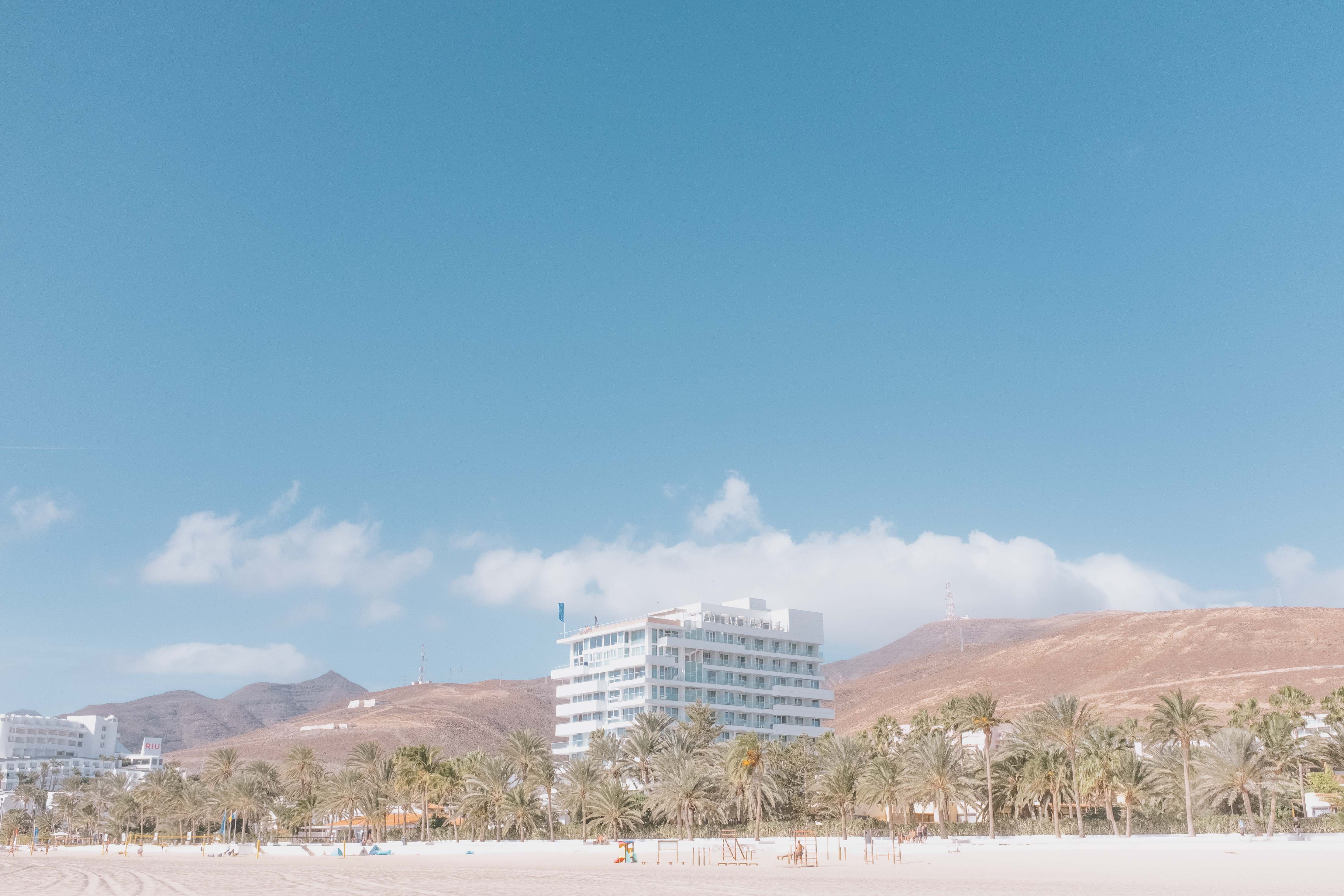 A big square hotel apartment block in the middle of the frame with a beach in the foreground. Taken by Connor Redmond on the Fujifilm X100F.
