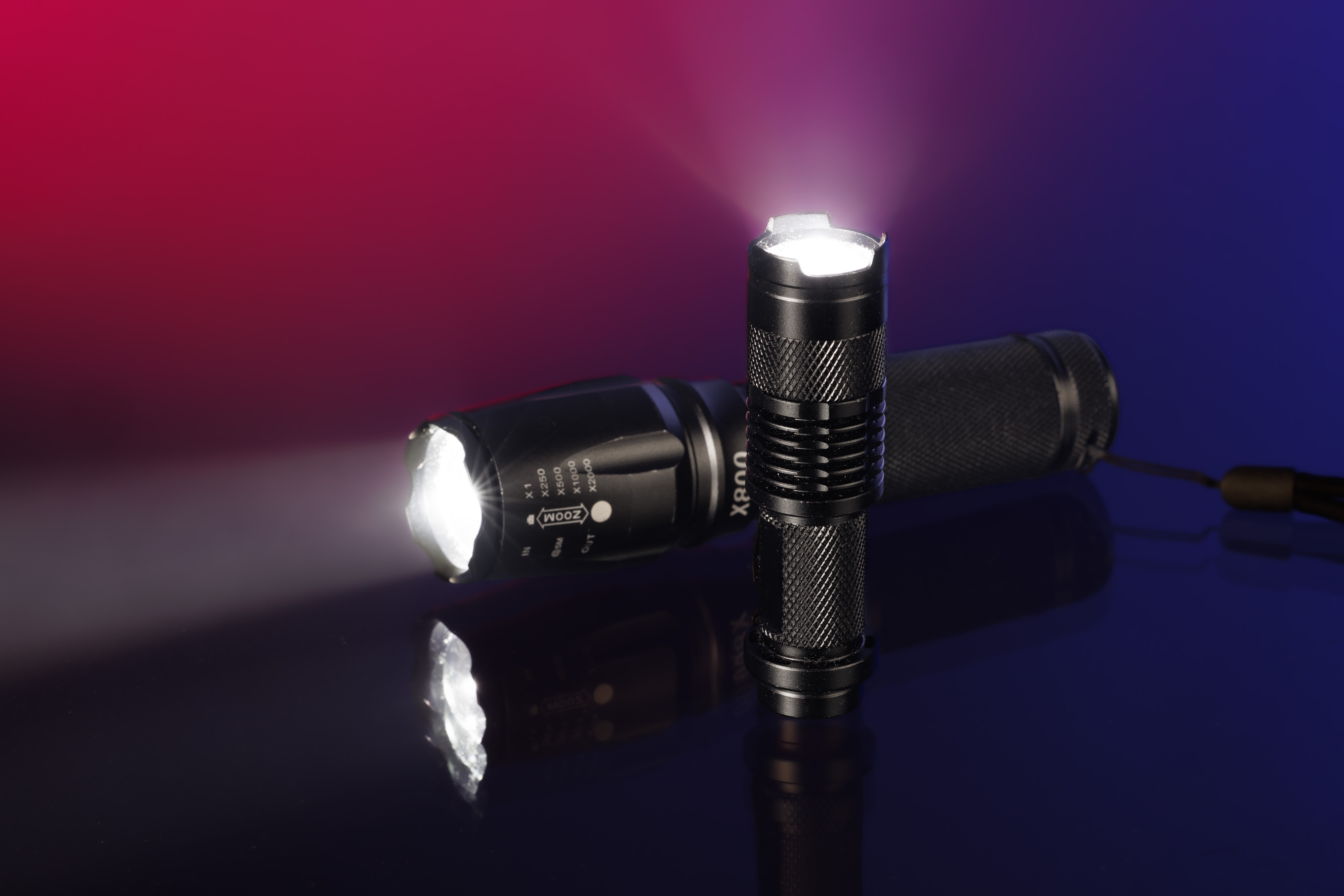 Twee LED zaklampen met blauwe en rode achtergrond