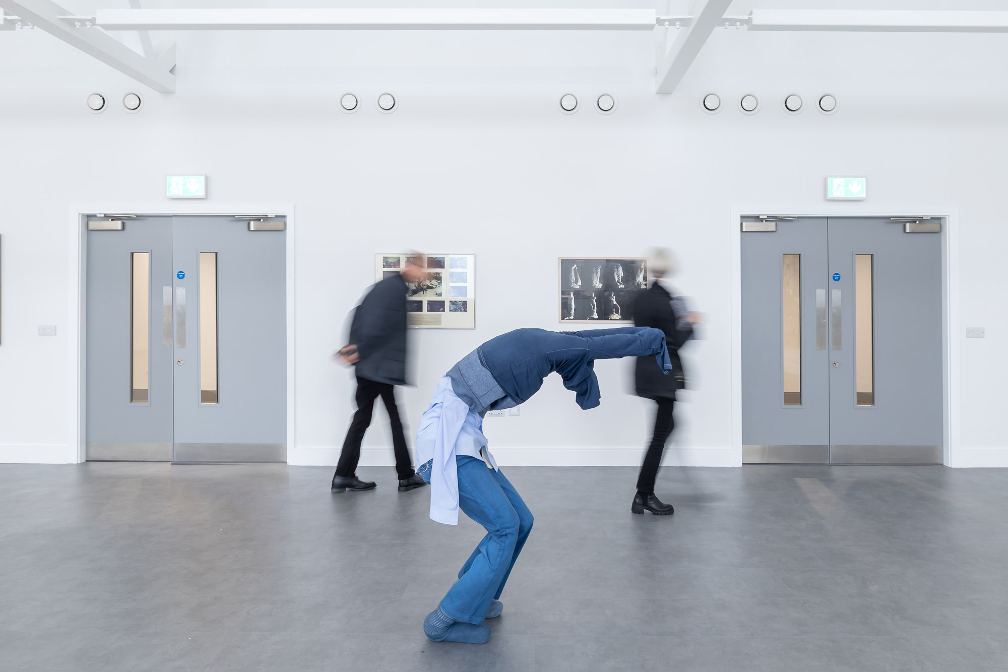Zwei Personen, die durch eine Ausstellung spazieren, mit einer Statue in Blue Jeans und Pullover im Vordergrund, aufgenommen von Paul Moore mit der Canon EOS R6 Mark II.

