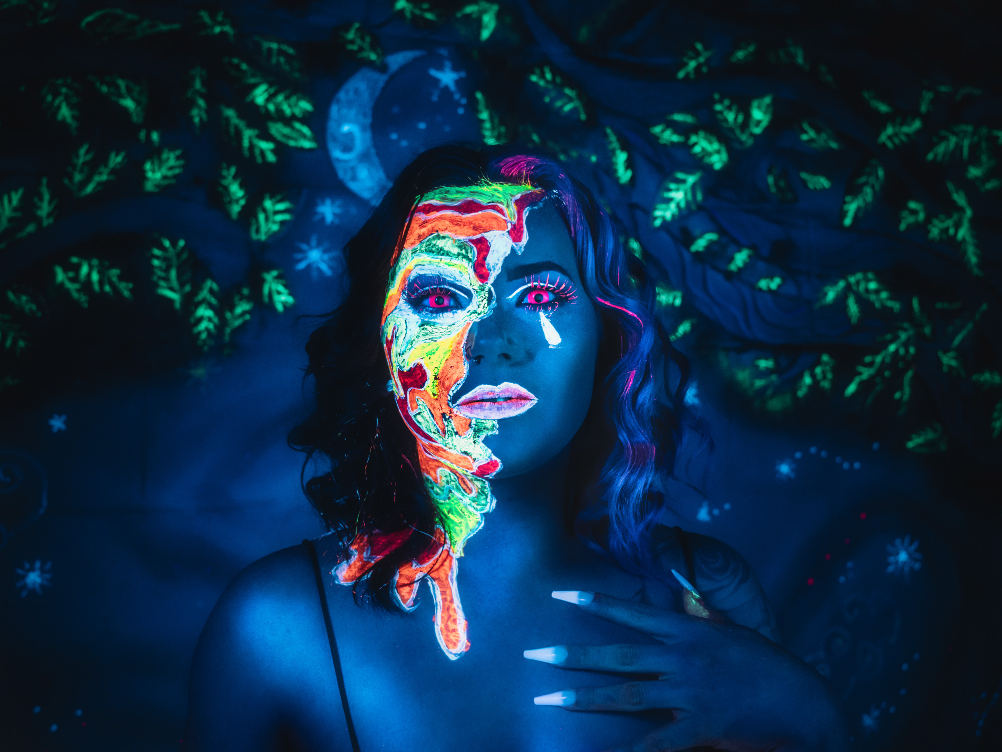 Une femme mannequin allongée sur le sol, portant une peinture UV pour le visage, photographiée par Emily Lowrey avec le Panasonic Lumix DC-GH6.