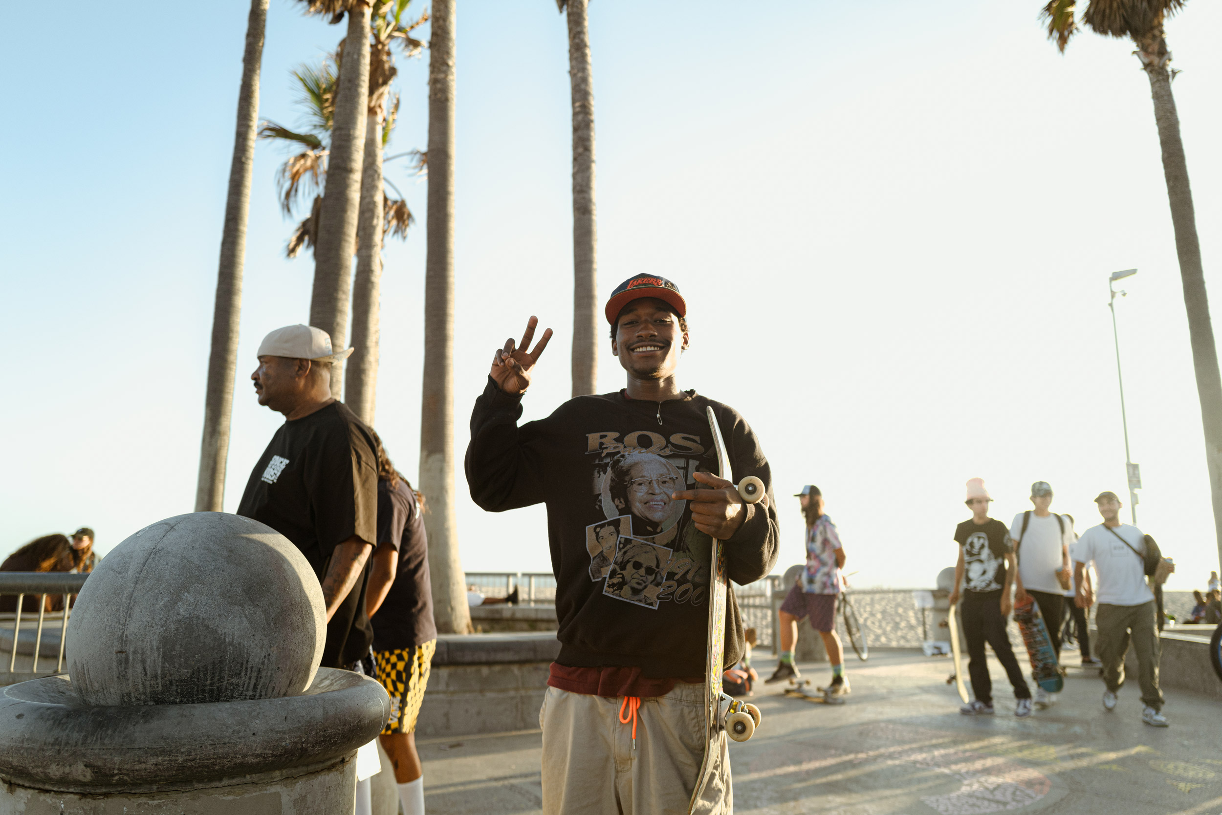 Skateboarder smiling and making a peace sign at Venice Beach in Los Angeles, California.