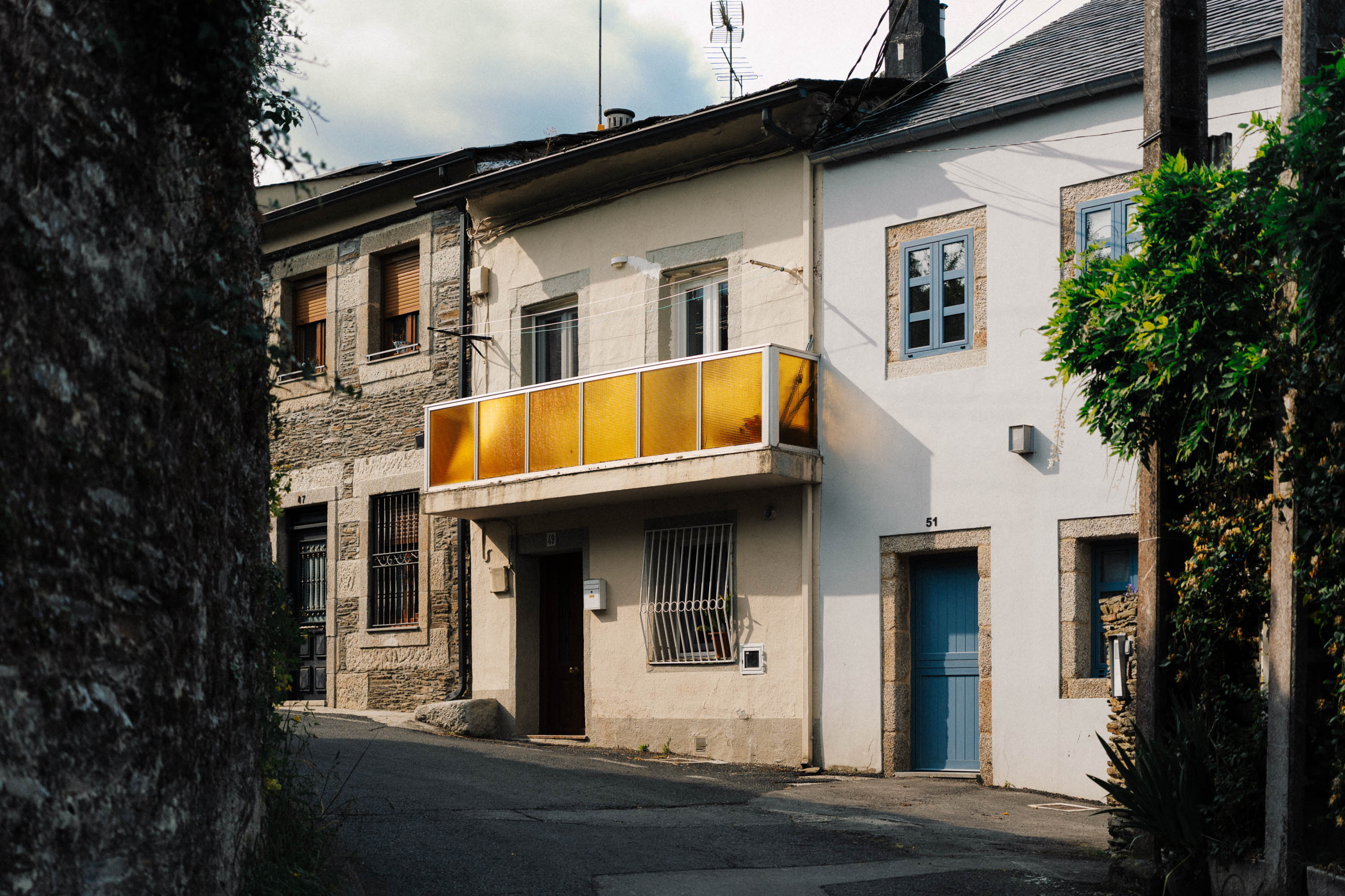 A picture of a Lugo street with a balcony with golden glass panes. Taken by Connor Redmond on the Sony A7C II. 