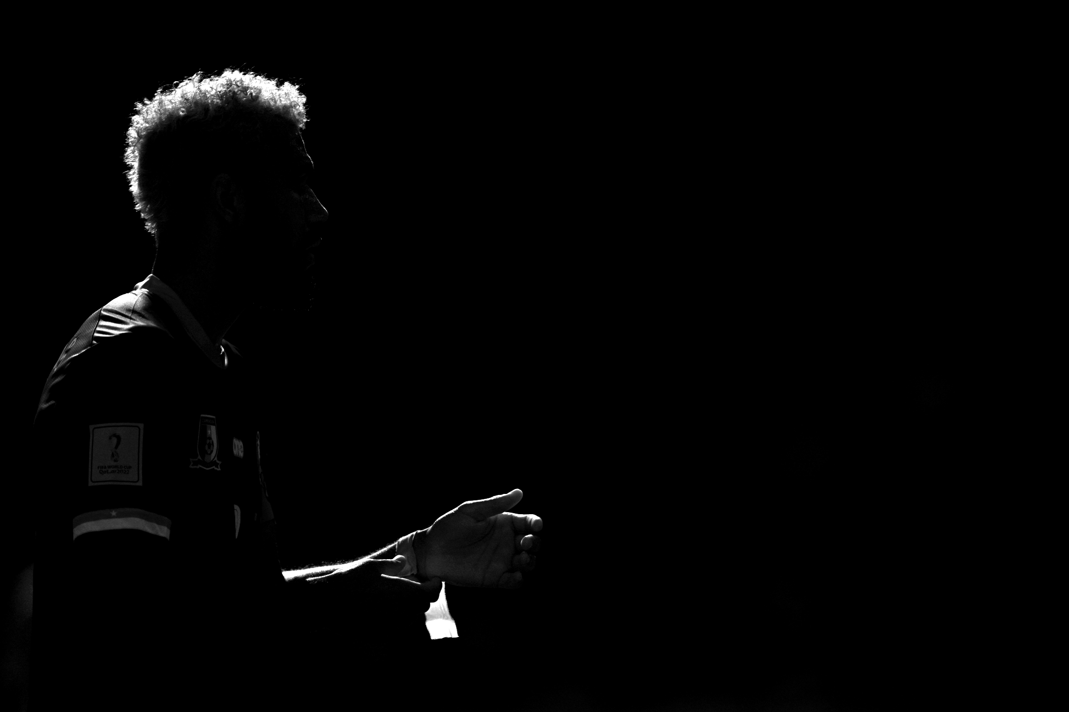 Photo sombre en noir et blanc d'un joueur de football éclairé de l'arrière pendant le match Cameroun - Suisse de la Coupe du monde 2022, prise avec un Nikon Z9 par Ryu Voelkel.