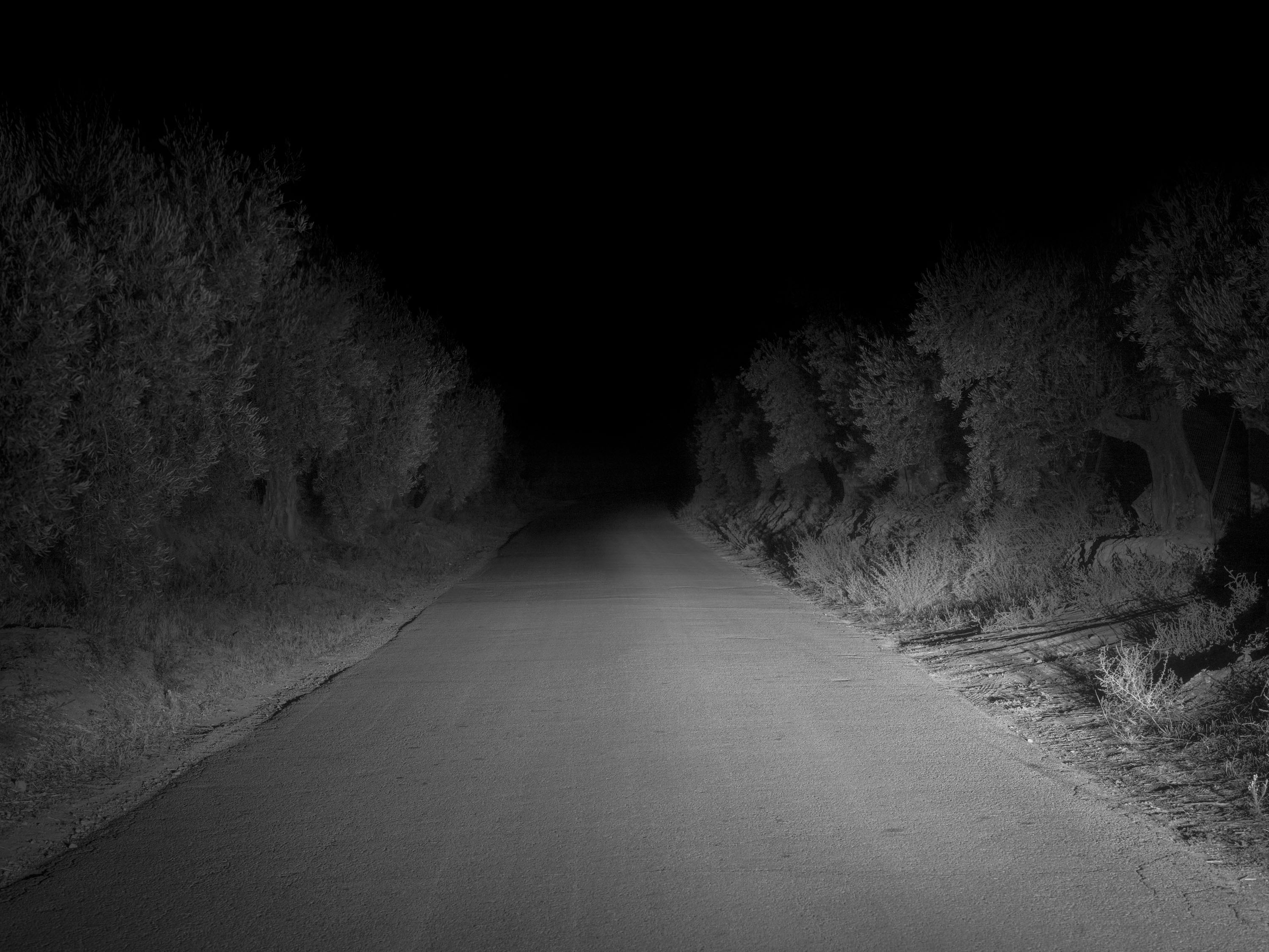 A black and white photo of a road illuminated by lights, shot on Phase One P45 Plus by Ian Howorth