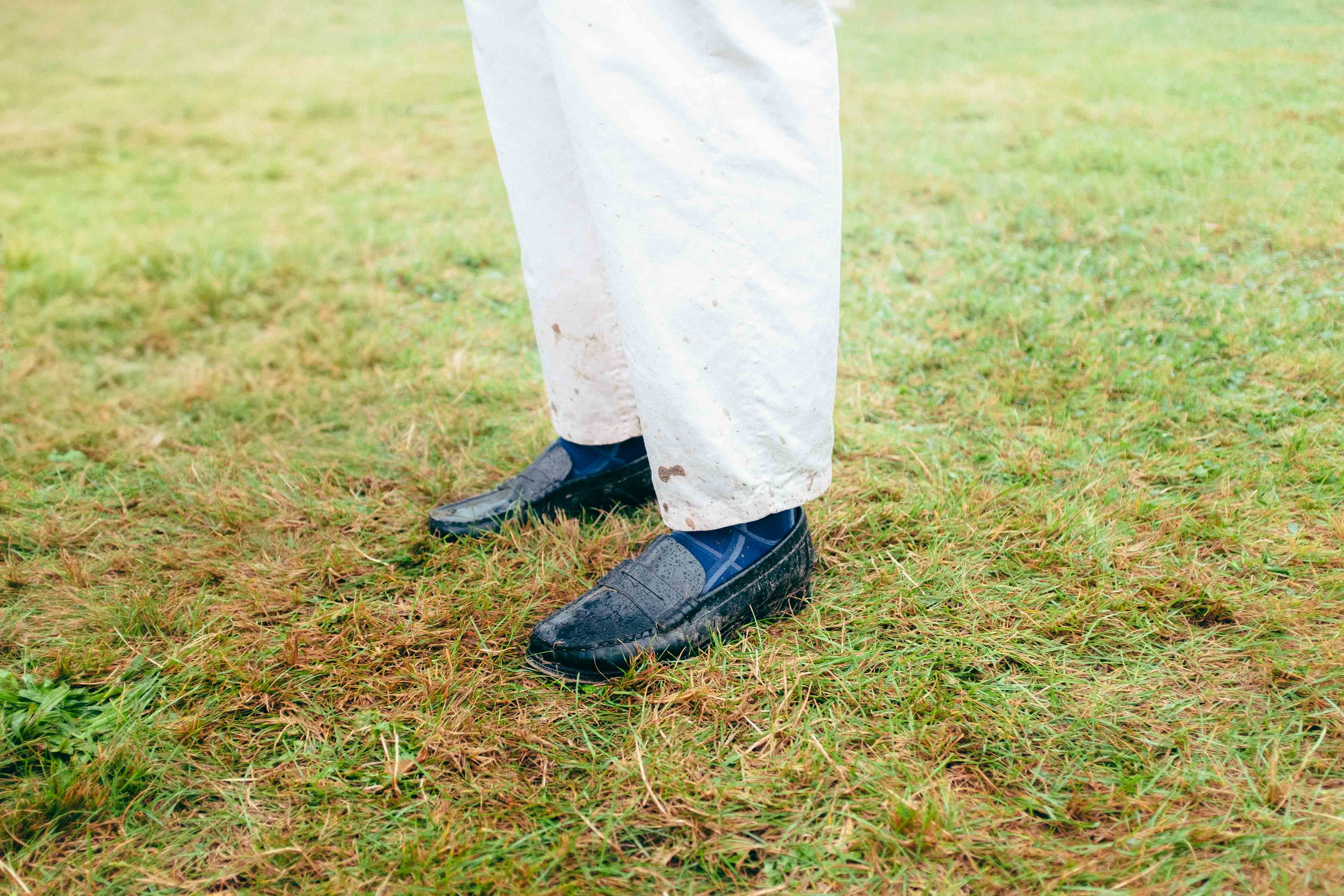 A person is dressed smartly, with legs and shoes visible, but is covered in dirt in a muddy field. This image was taken by Connor Redmond on the Fujifilm X100F.
