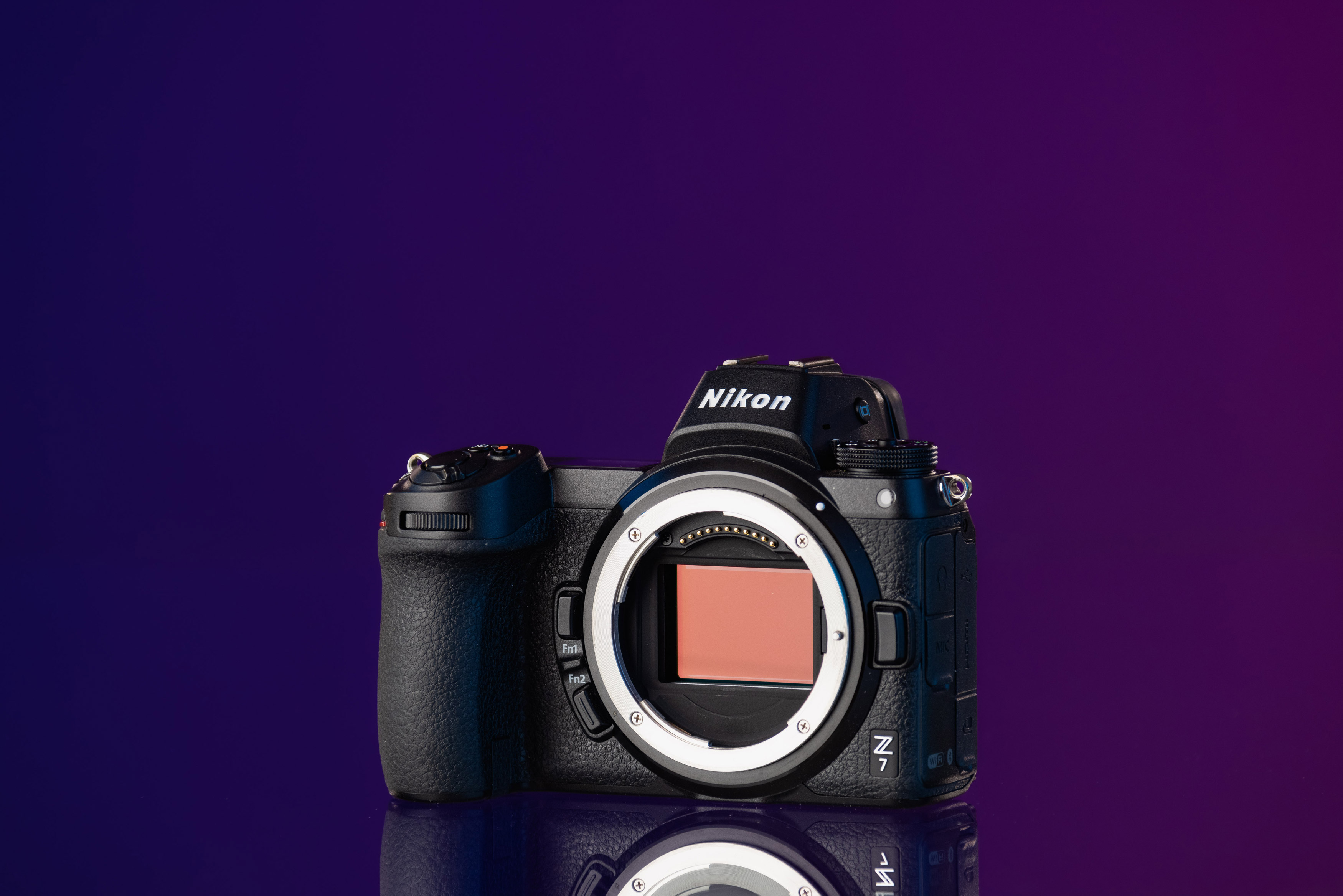 Ein Foto einer spiegellosen Vollformatkamera Nikon Z7, deren rosafarbener Sensor aufrecht stehend vor einem lila Hintergrund belichtet wird