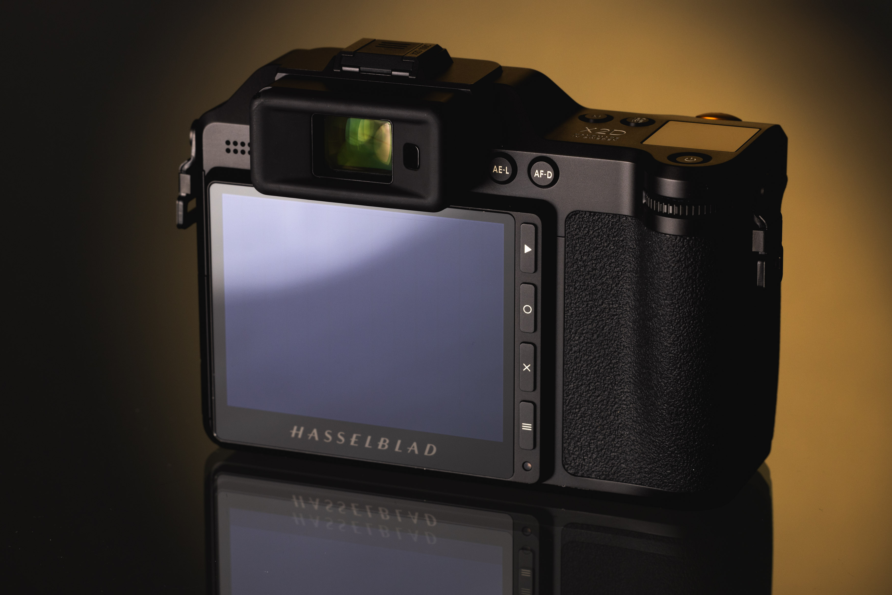 Touchscreen auf der Rückseite der Hasselblad X2D 100C vor einem orange-schwarzen Hintergrund