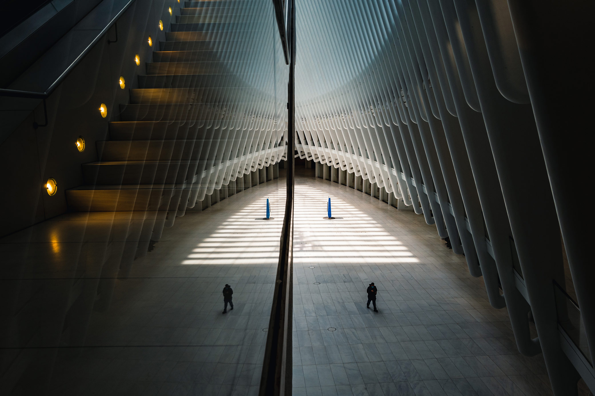 Persoon loopt door leeg Oculus-gebouw in New York City, gefotografeerd door Manuel Pena.