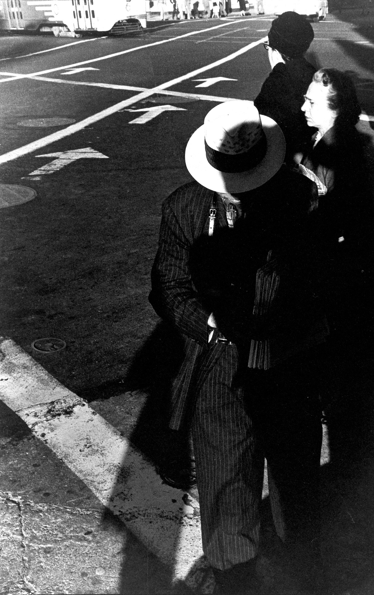 Fotografía callejera en blanco y negro de Ralph Gibson en la que se ve a personas caminando junto a una carretera, tomada con una Leica M2. 