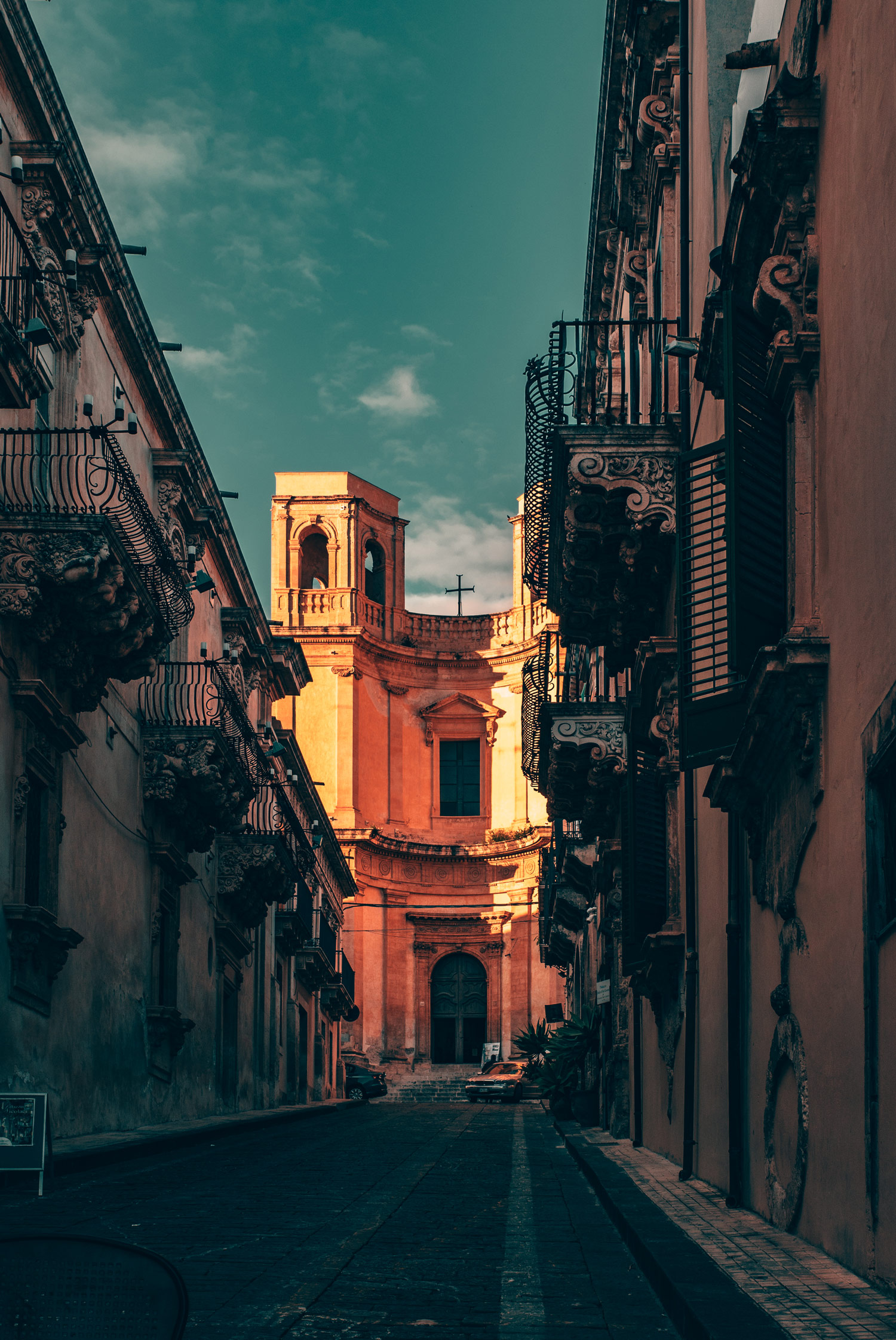 A street under in shadow with a building in sunlight at the end. Shot by Emily Lowrey with the Panasonic Lumix DC-GH5.