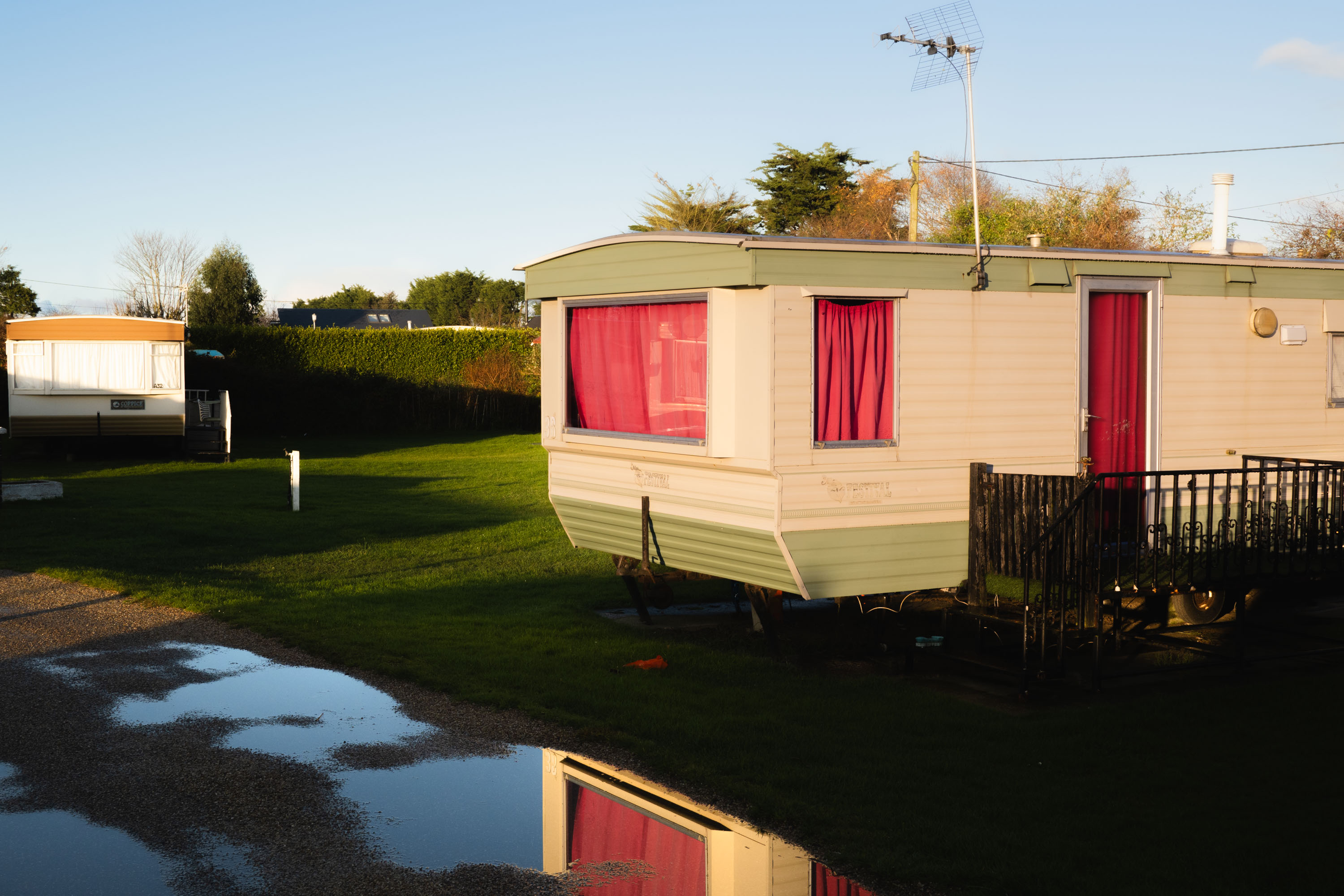 A vintage caravan in Norfolk with pink curtains. By Ian Howorth.