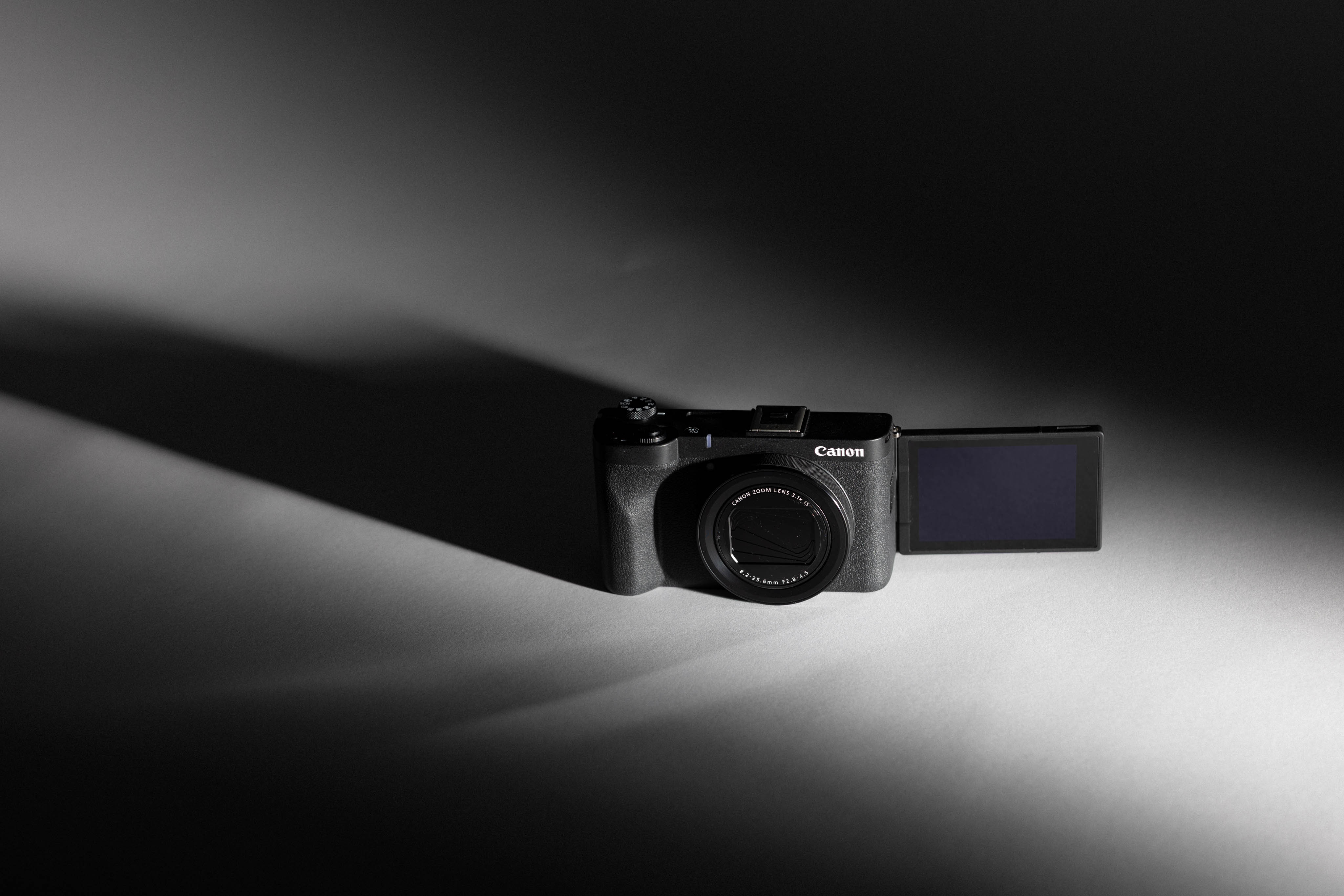 Kitshot of a used Canon PowerShot V1 from MPB taken on a black and white background with moody lighting with the screen popped out, by Connor Redmond.