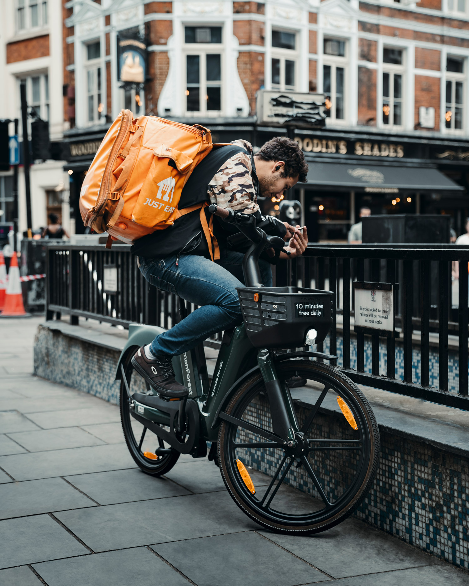 A cyclist looks down on a London Underground entrance