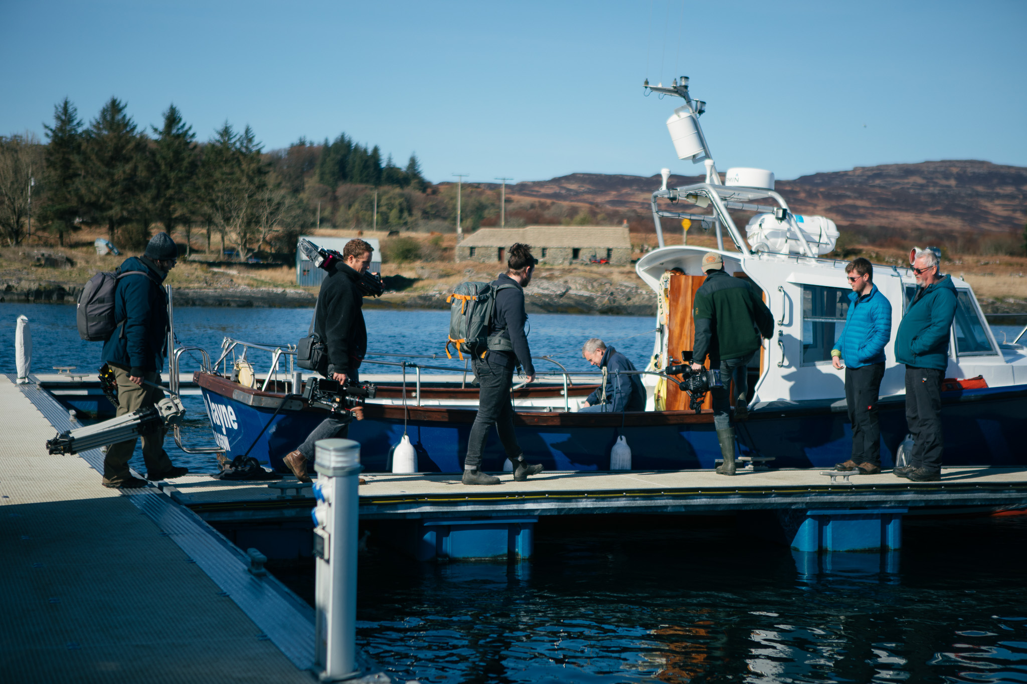 A group of people on a dock walking to get on a boat