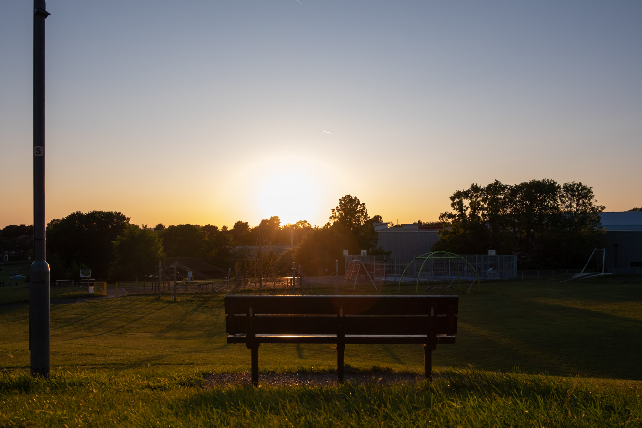 A bench in a park as the sun goes down