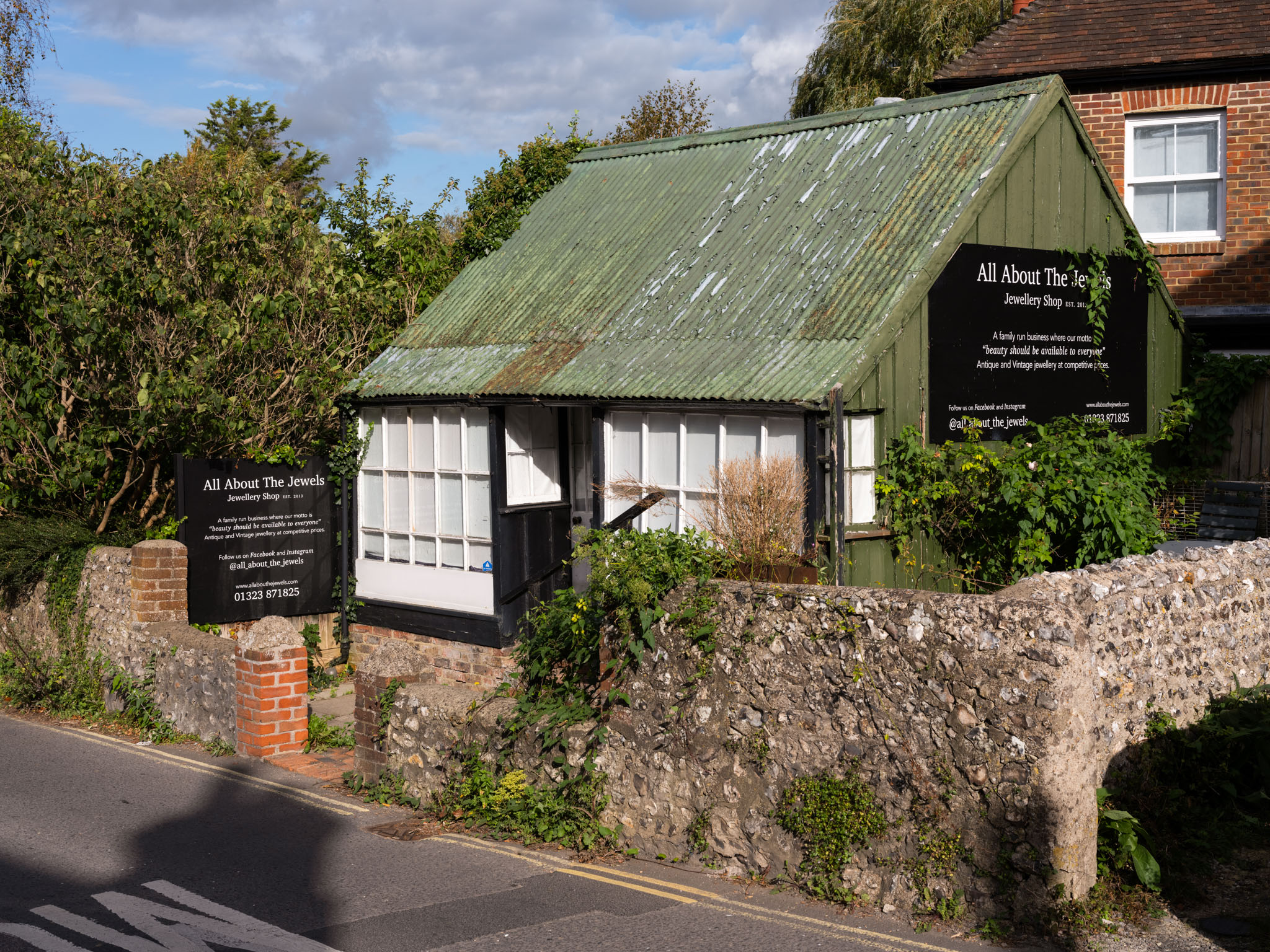 A green metal shed like building that is being used as shop