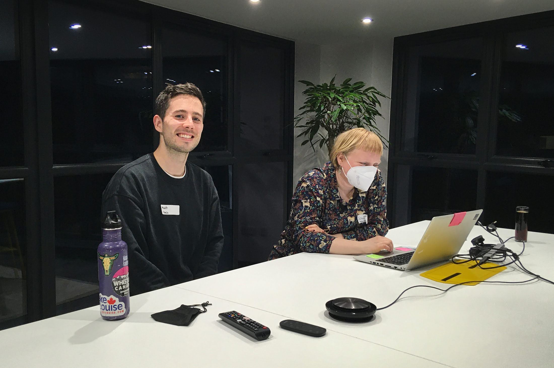 MPB Brighton codebar event: A person smiling and a person working on their laptop attending a MPB and codebar event in Brighton.